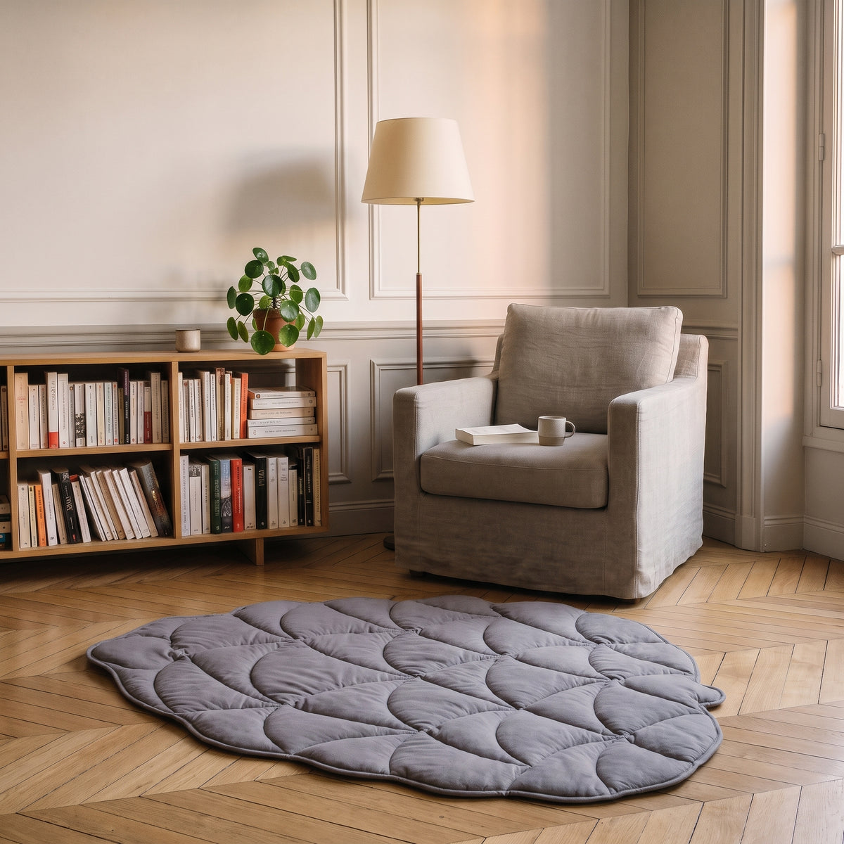 Tapis en forme de feuille gris parme au bord festonné devant un fauteuil