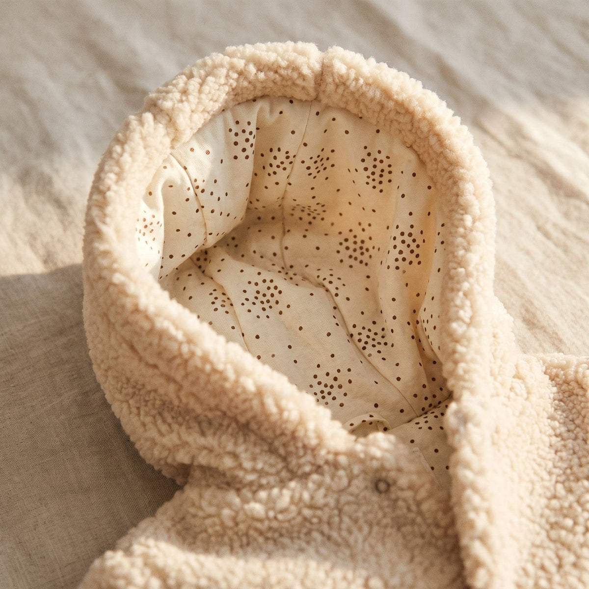 Capuche de la combinaison bébé, doublée d'un coton ivoire à petits points