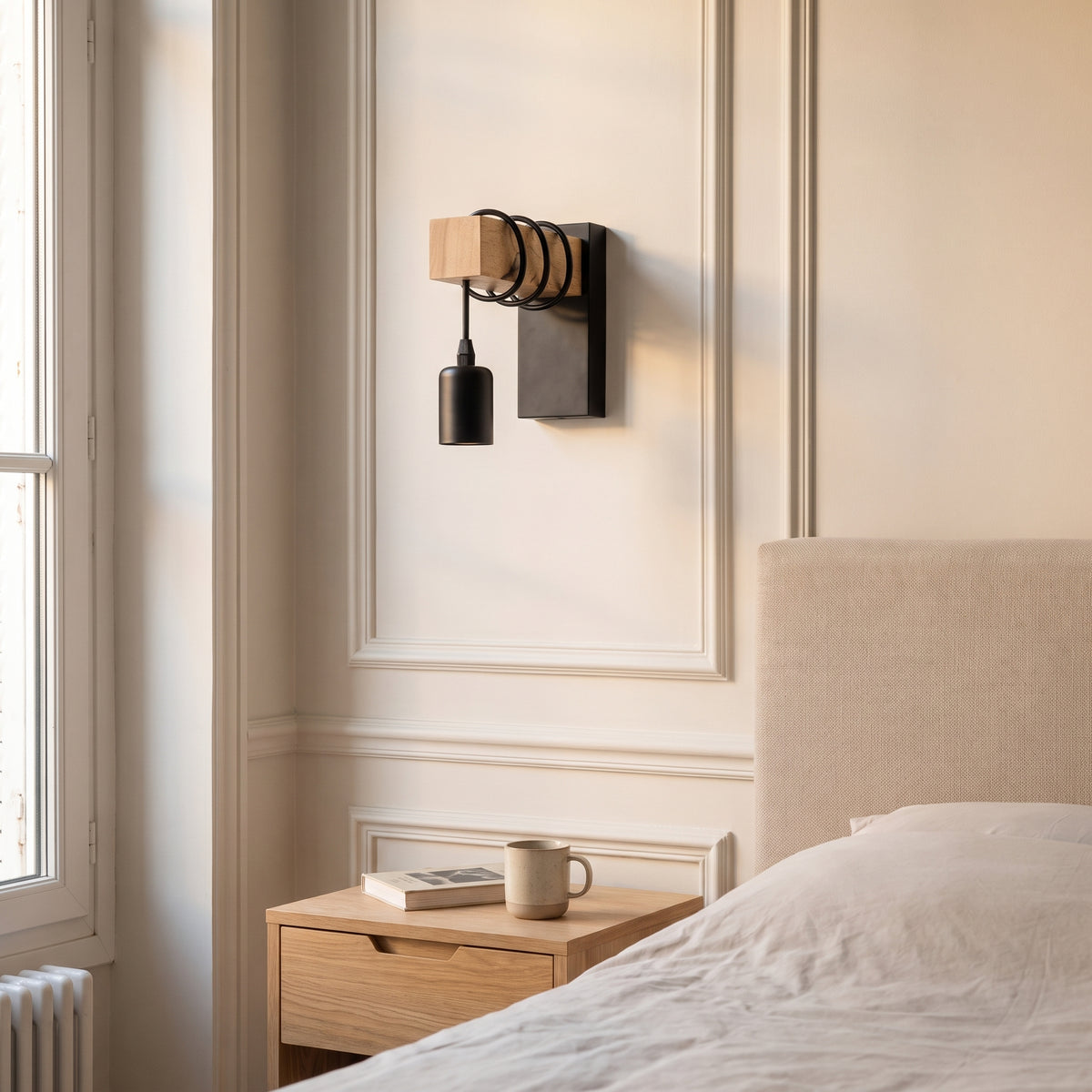 Applique murale en bois et métal noir au-dessus d'une table de chevet, douille nue, en lumière du jour