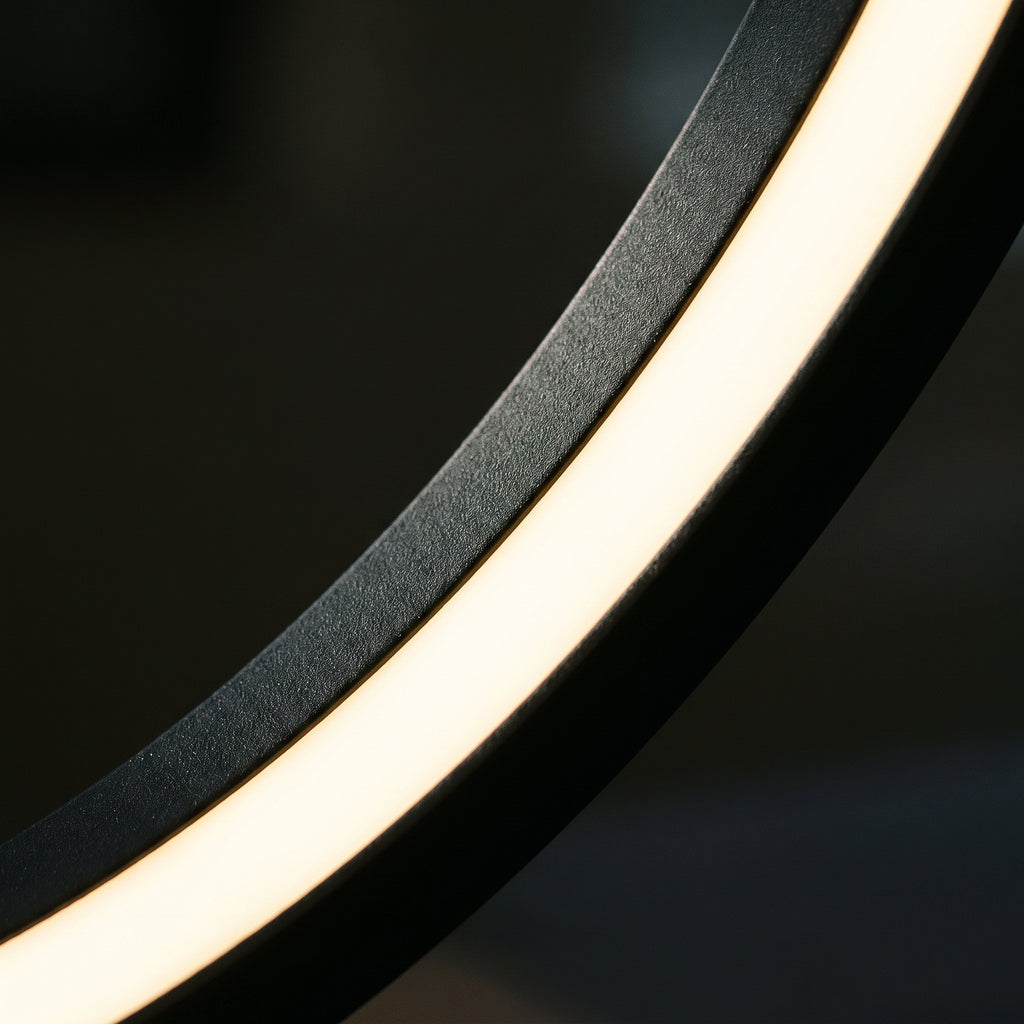 Détail du bord intérieur de l'ovale en métal noir mat et du ruban de LED allumé