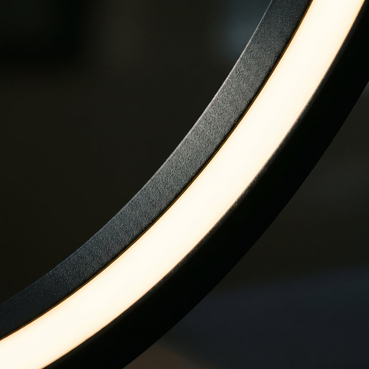 Détail du bord intérieur de l'ovale en métal noir mat et du ruban de LED allumé