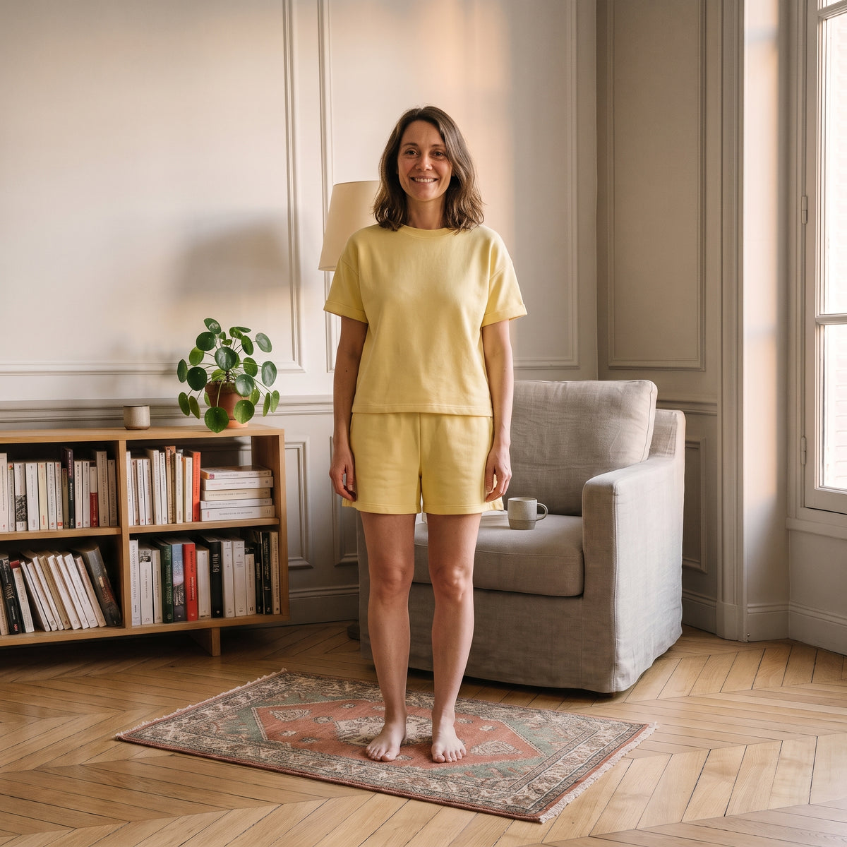 Femme en ensemble short et t-shirt en coton jaune pâle dans un coin lecture