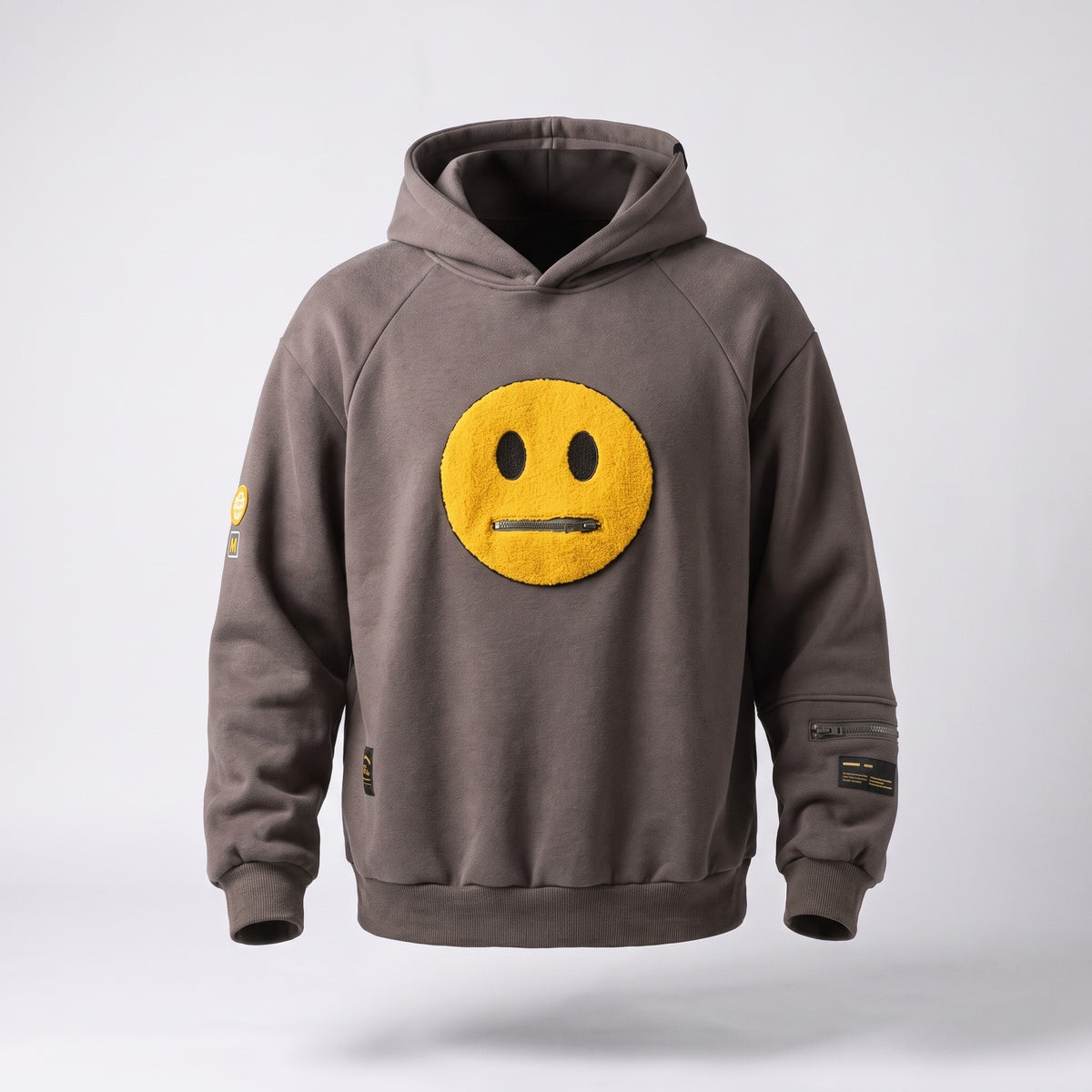 Le sweat gris fonce porte par un mannequin invisible, vu de face en entier : capuche a plat dans le dos, coutures de manche en biais depuis le col, poche zippee sur un avant-bras