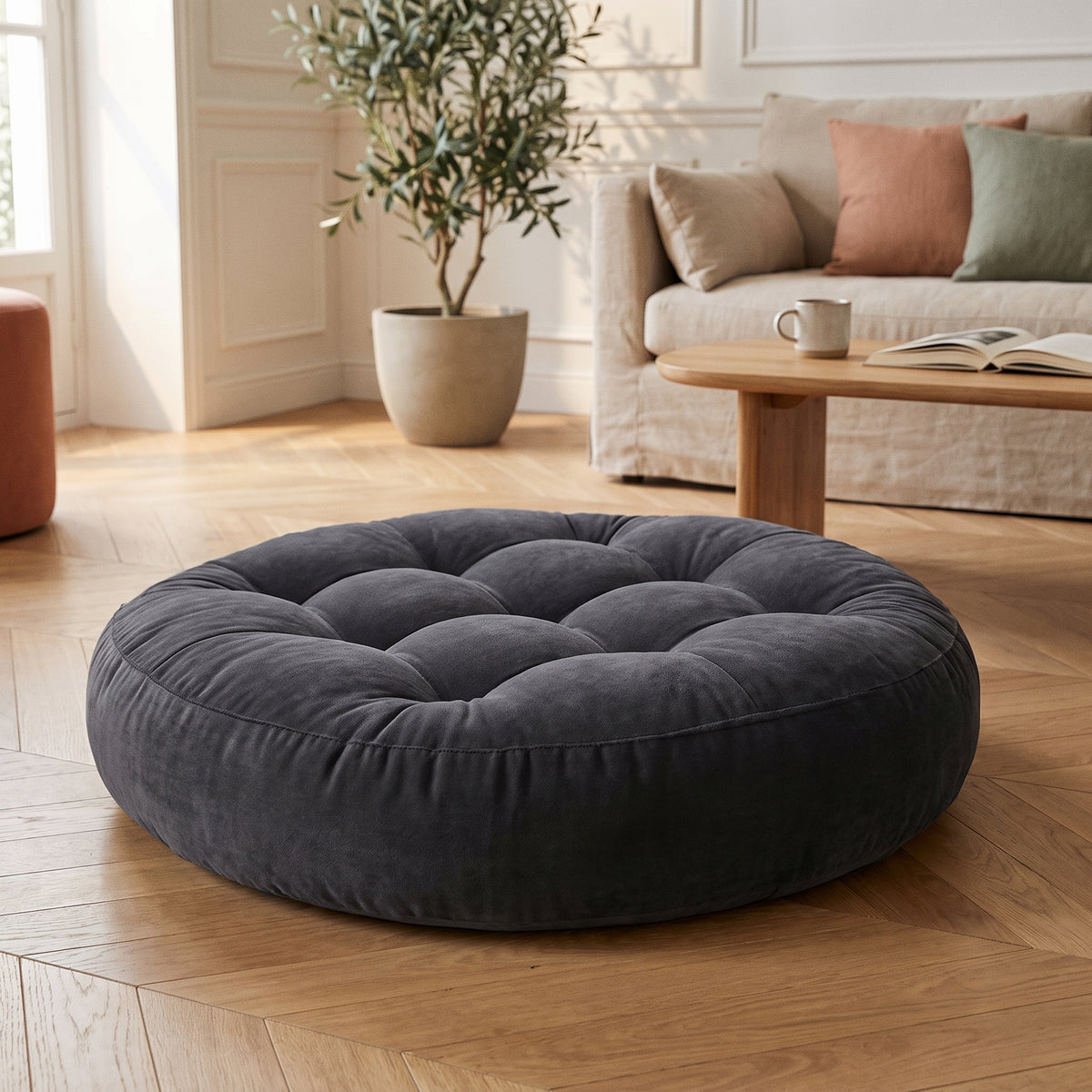 Coussin de sol rond gris anthracite en velours, quartiers capitonnés et bourrelet de pourtour