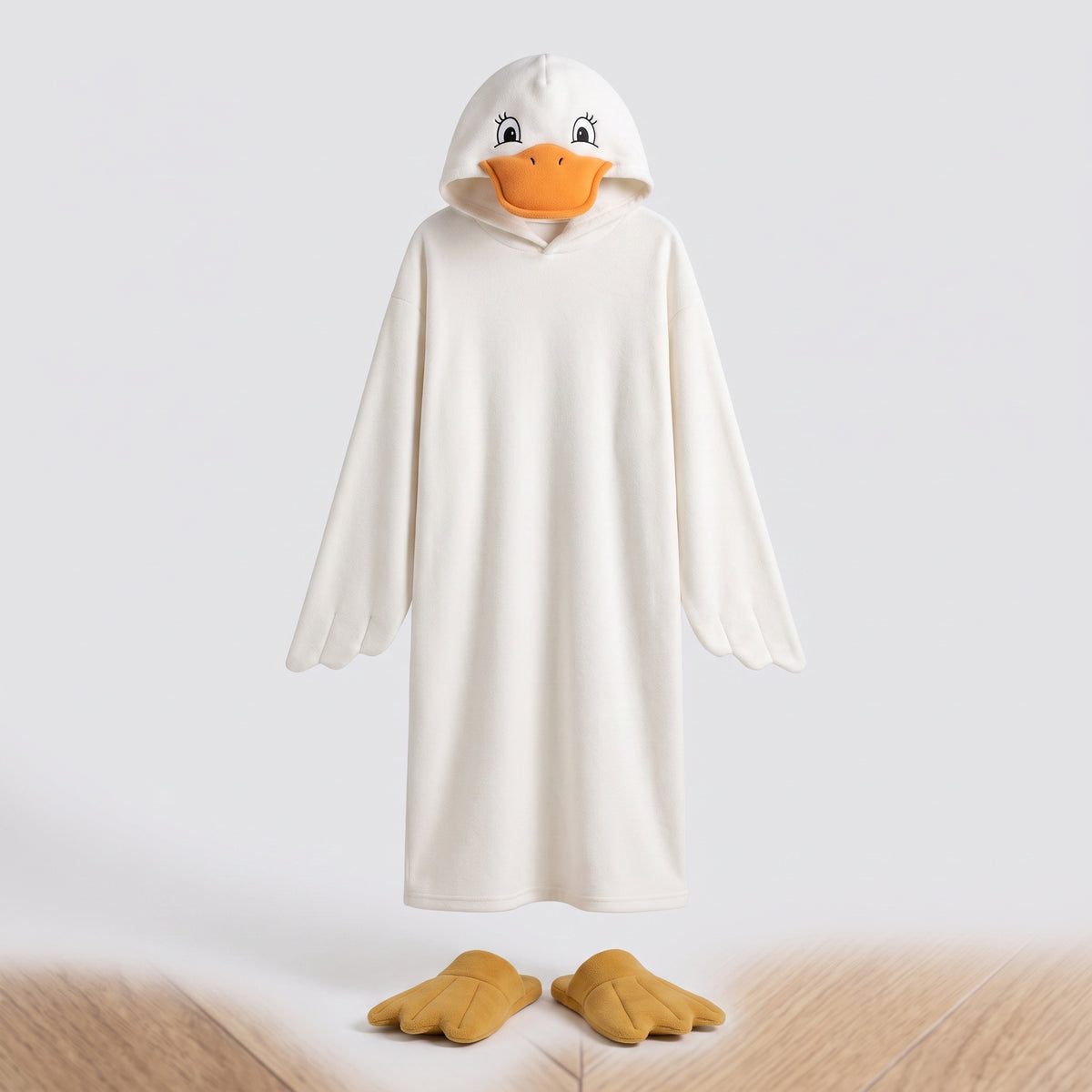Pyjama canard présenté seul de face sur fond clair, capuche à tête de canard et paire de chaussons palmés posée devant l'ourlet