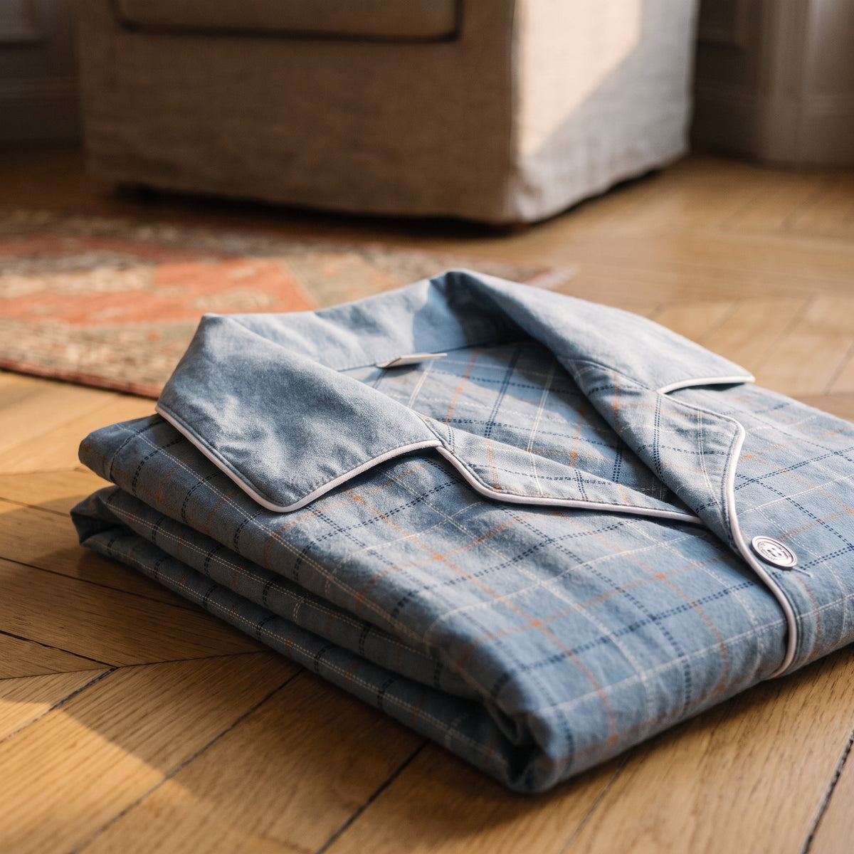 Veste de pyjama en coton bleu clair pliée, col uni et revers à carreaux bordés d'un liseré blanc