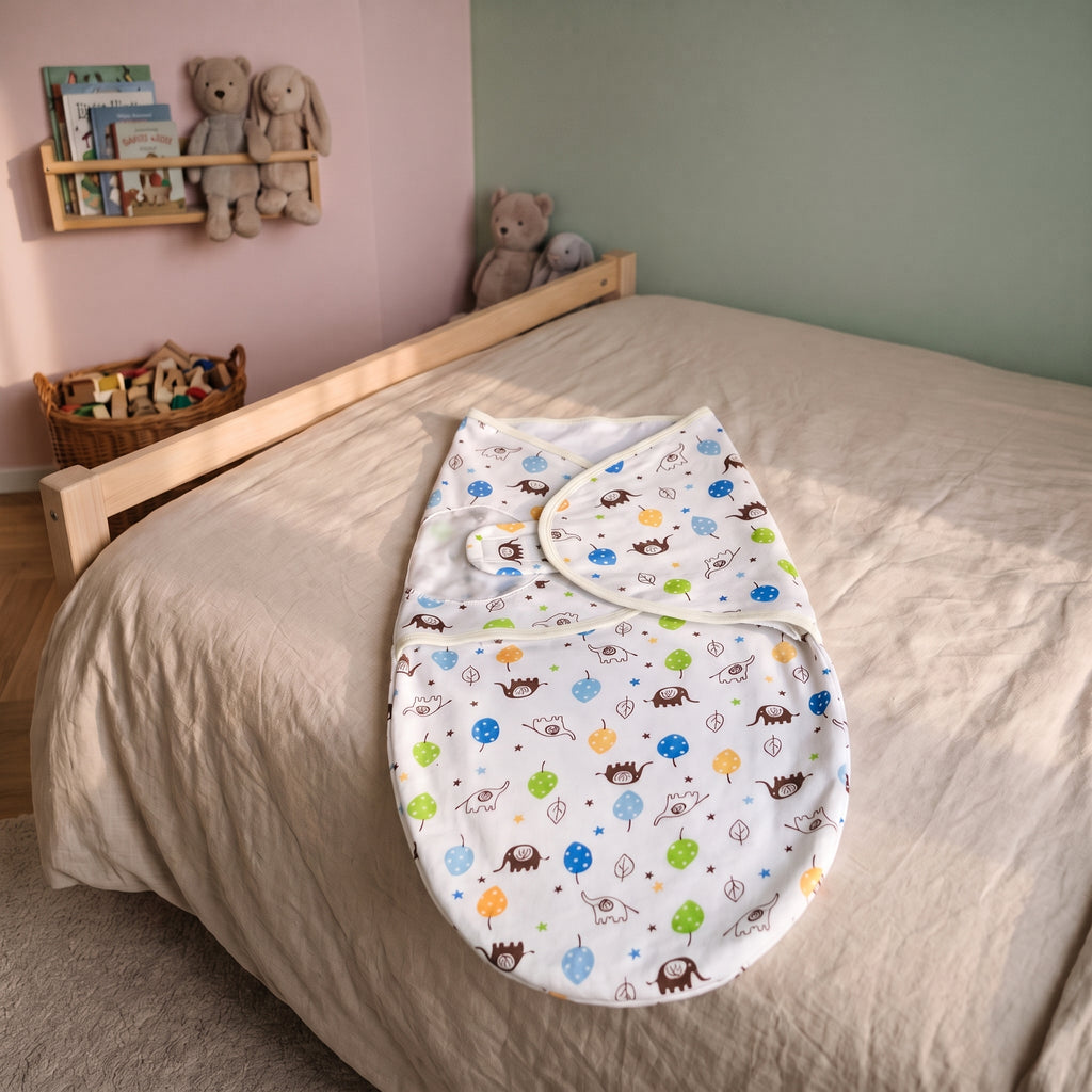 Sac de couchage d'emmaillotage pour bébé motif éléphants, posé à plat sur un lit d'enfant