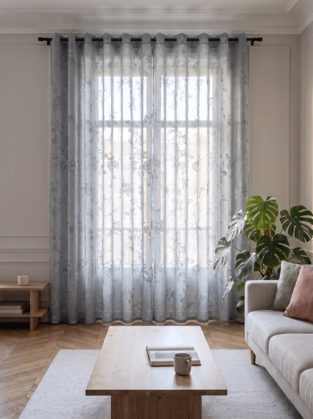 Voilage transparent gris à motif feuillage, pans fermés devant la fenêtre d'un salon
