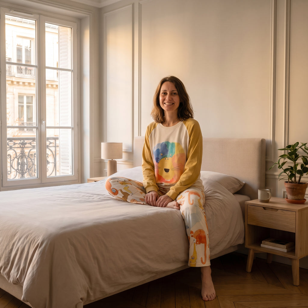 Femme assise au bord du lit en pyjama de coton imprimé animaux