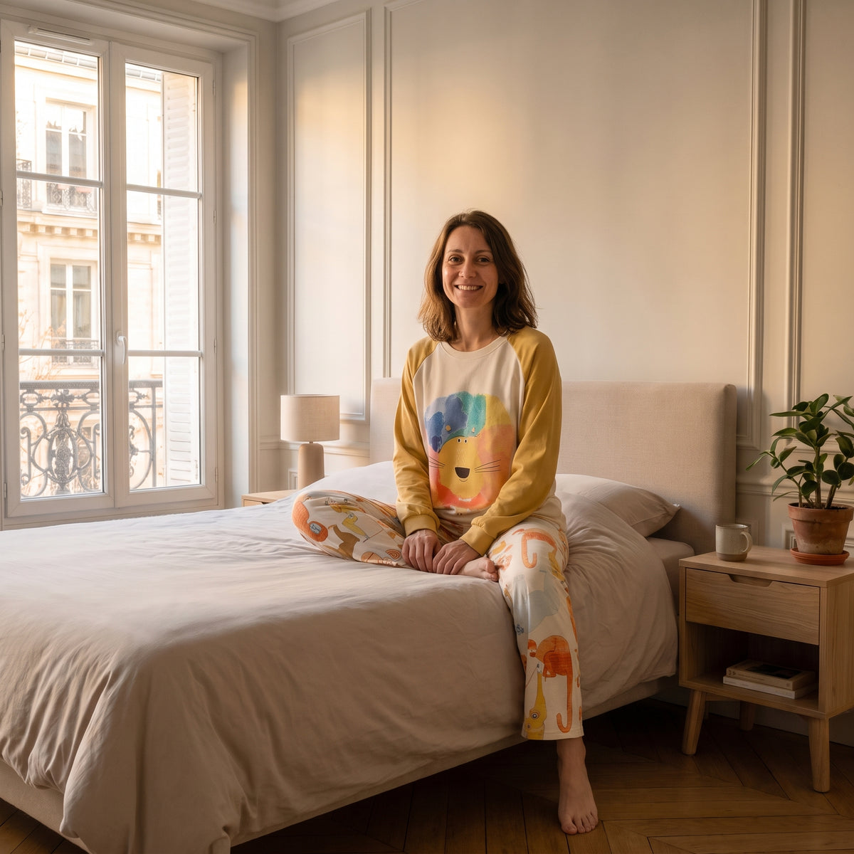 Femme assise au bord du lit en pyjama de coton imprimé animaux