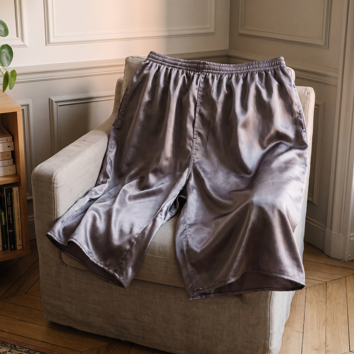 Short de pyjama en satin gris posé à plat, coupe boxer et jambes larges