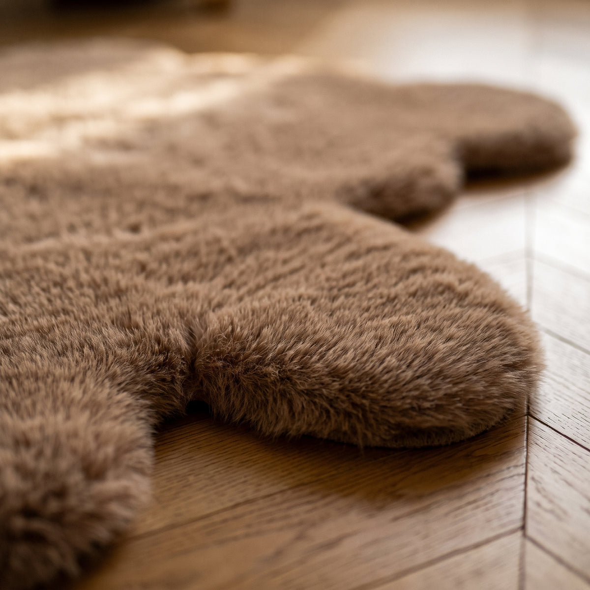 Gros plan du poil du tapis ourson marron au bord du parquet