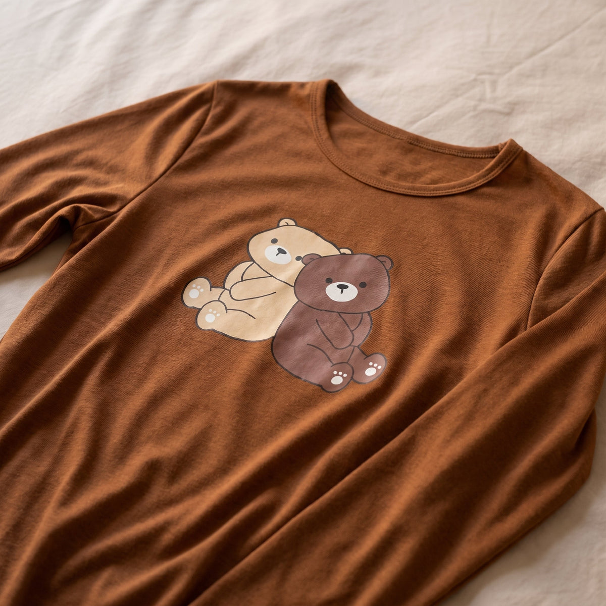 Gros plan du dessin des deux oursons sur le haut de pyjama marron pose a plat