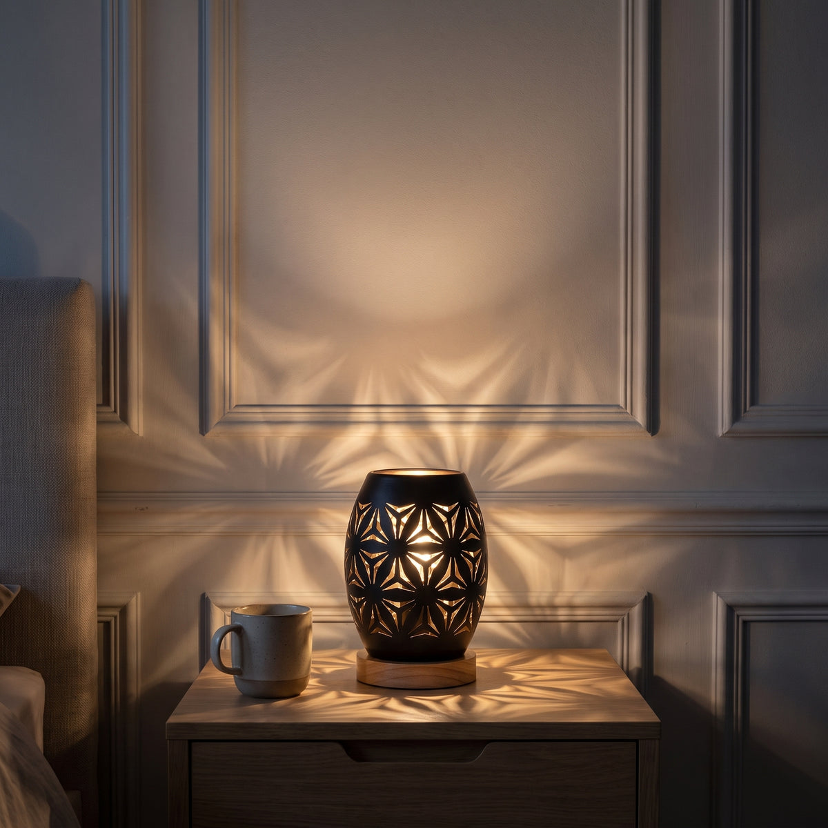Lampe photophore allumée projetant ses étoiles sur le mur de la chambre