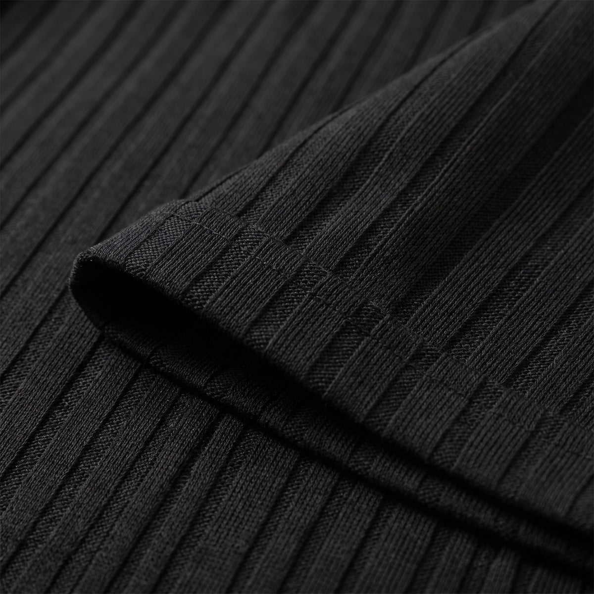 Gros plan des fines nervures verticales du tissu plissé noir