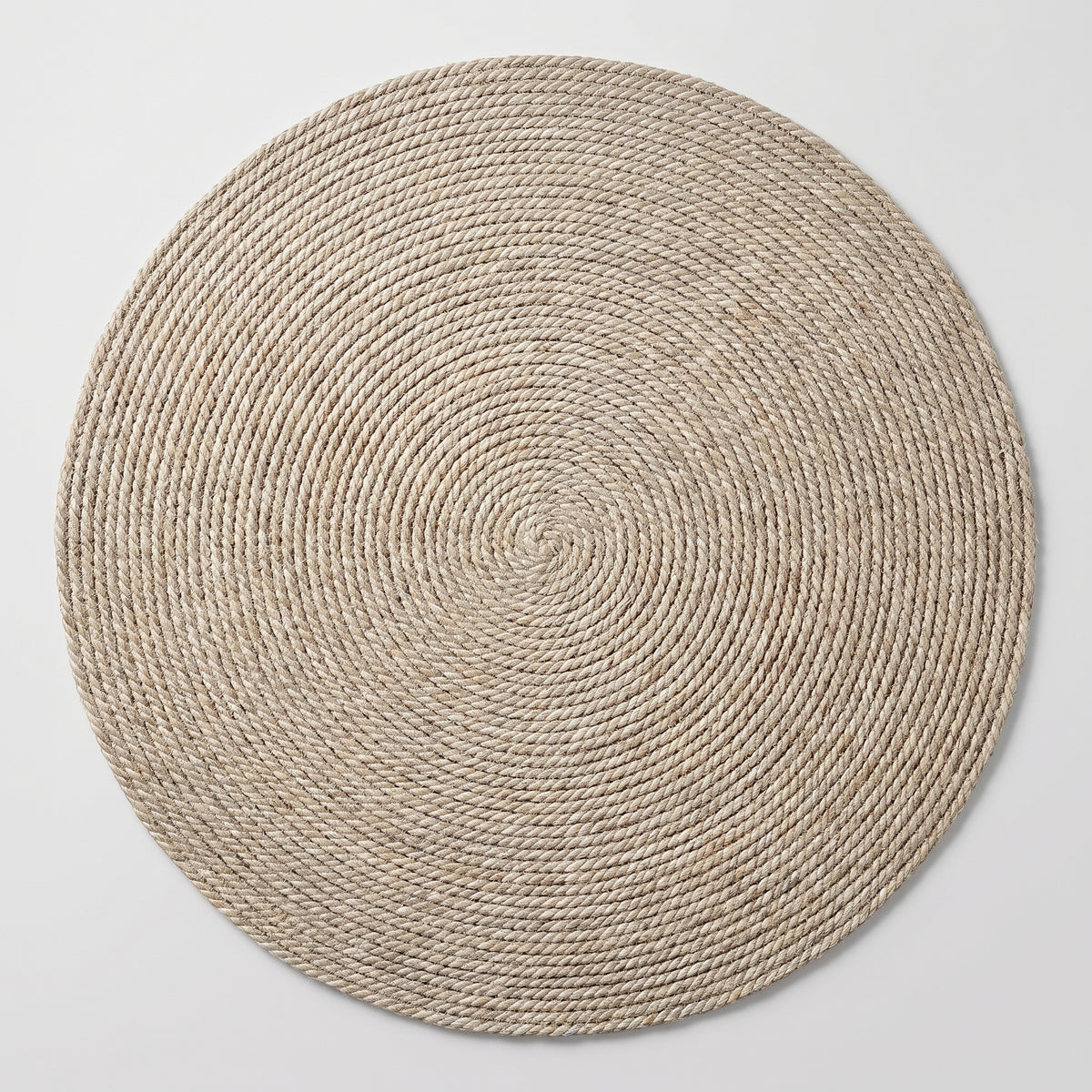 Tapis rond en sisal beige clair vu du dessus, entier, sur un fond clair