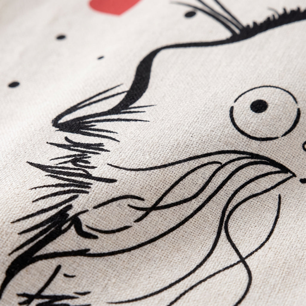 Gros plan du trait noir du chat sur la toile écrue du rideau