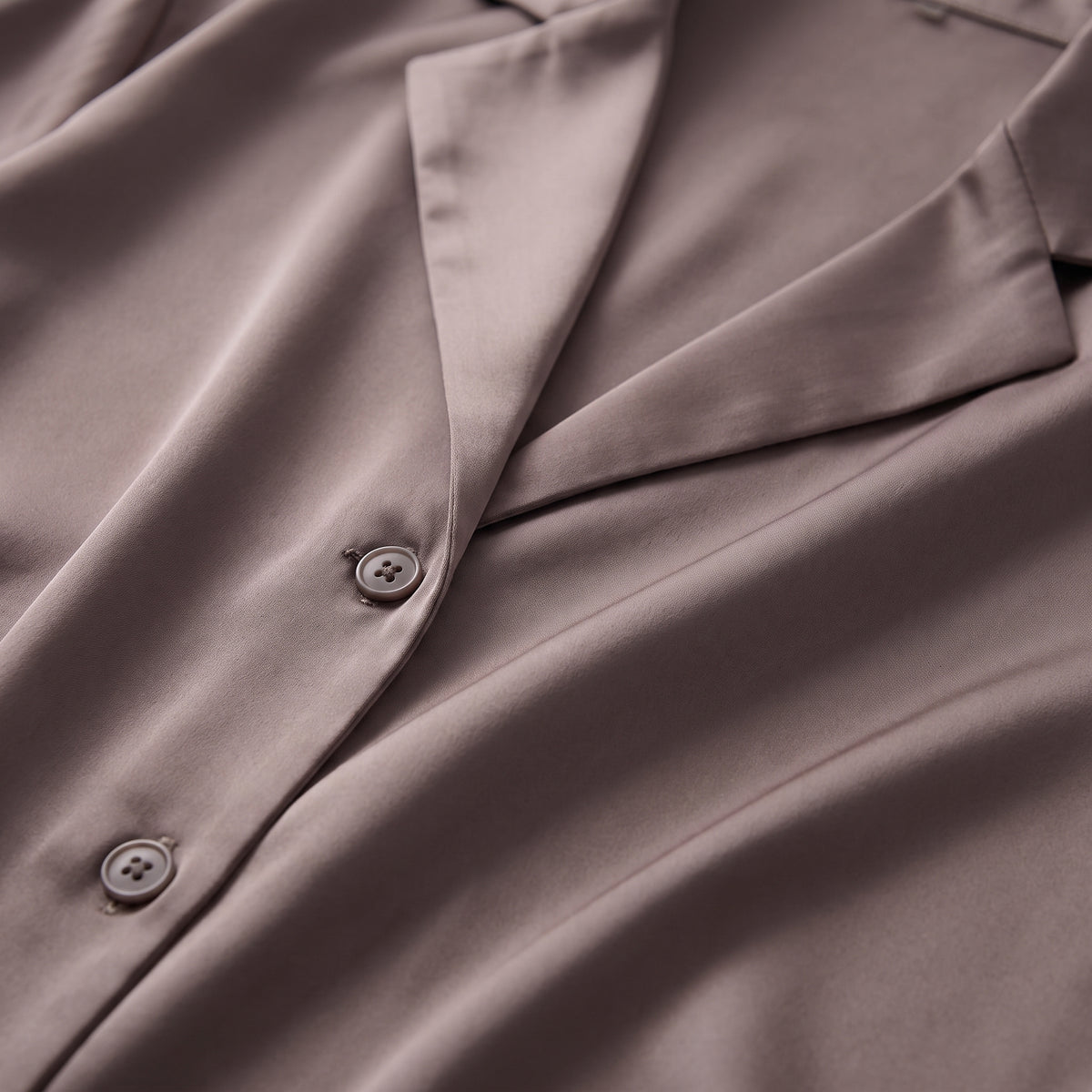 Col et boutons de la chemise en satin, tombé du tissu vu de près