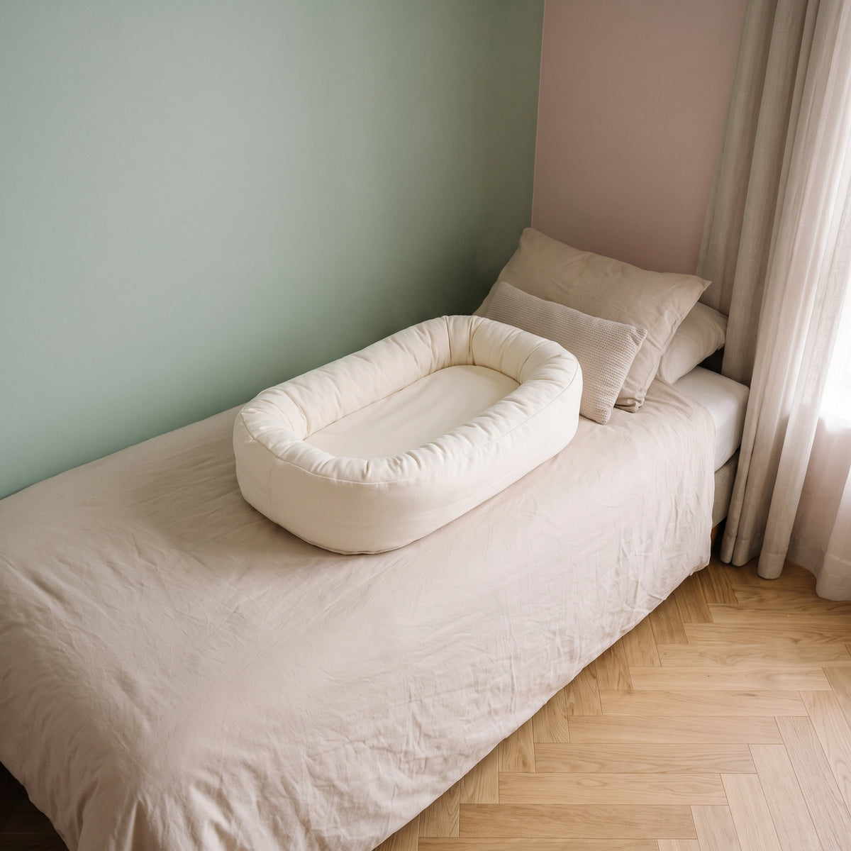 Couffin bébé en coton posé sur le lit, coloris écru