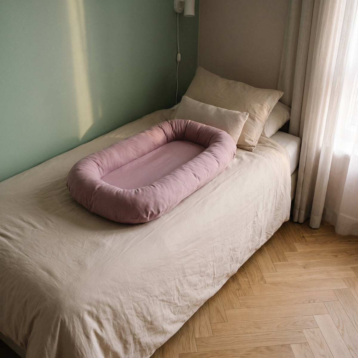 Couffin bébé en coton posé sur le lit, coloris mauve