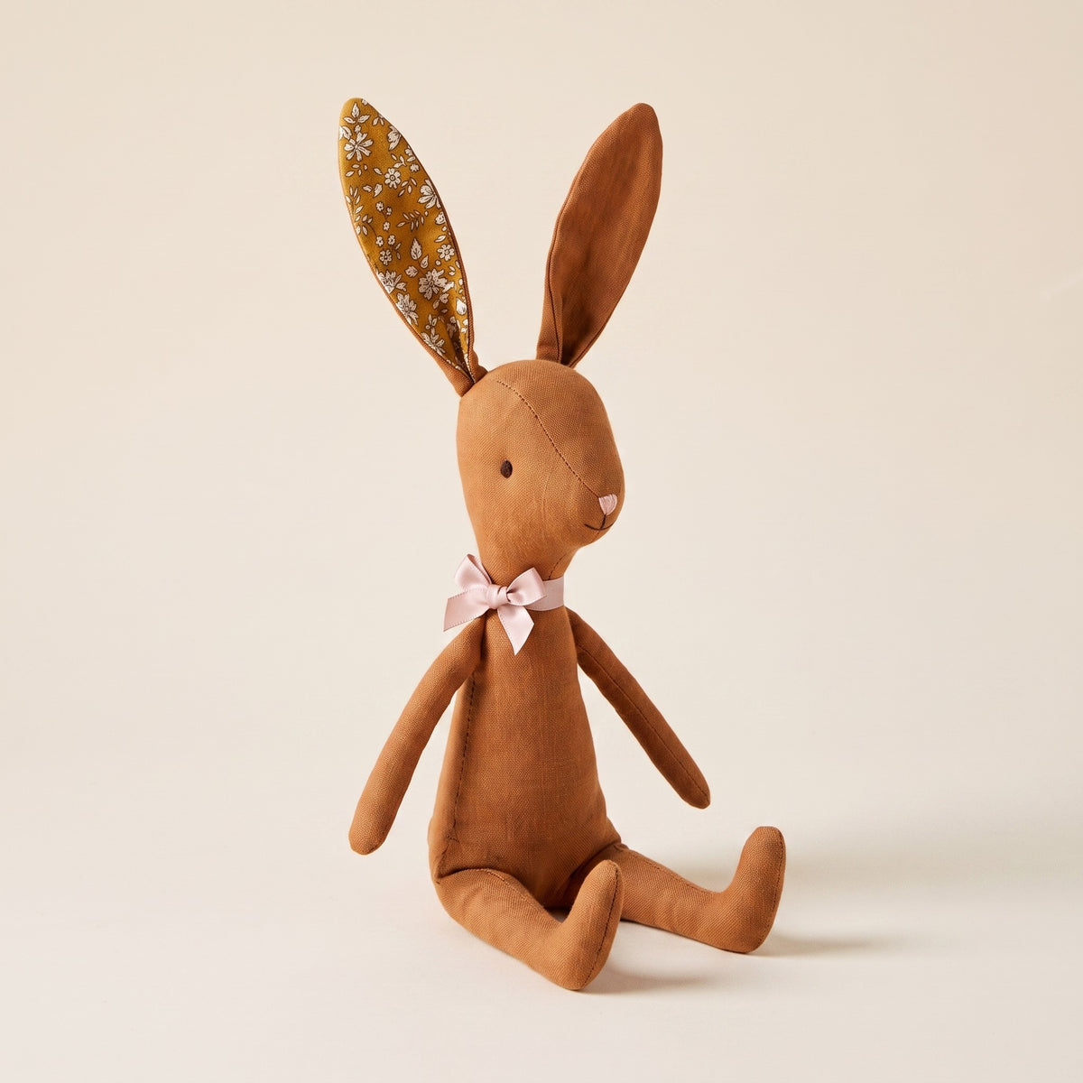 Doudou lapin marron en coton, vu en entier assis sur fond écru
