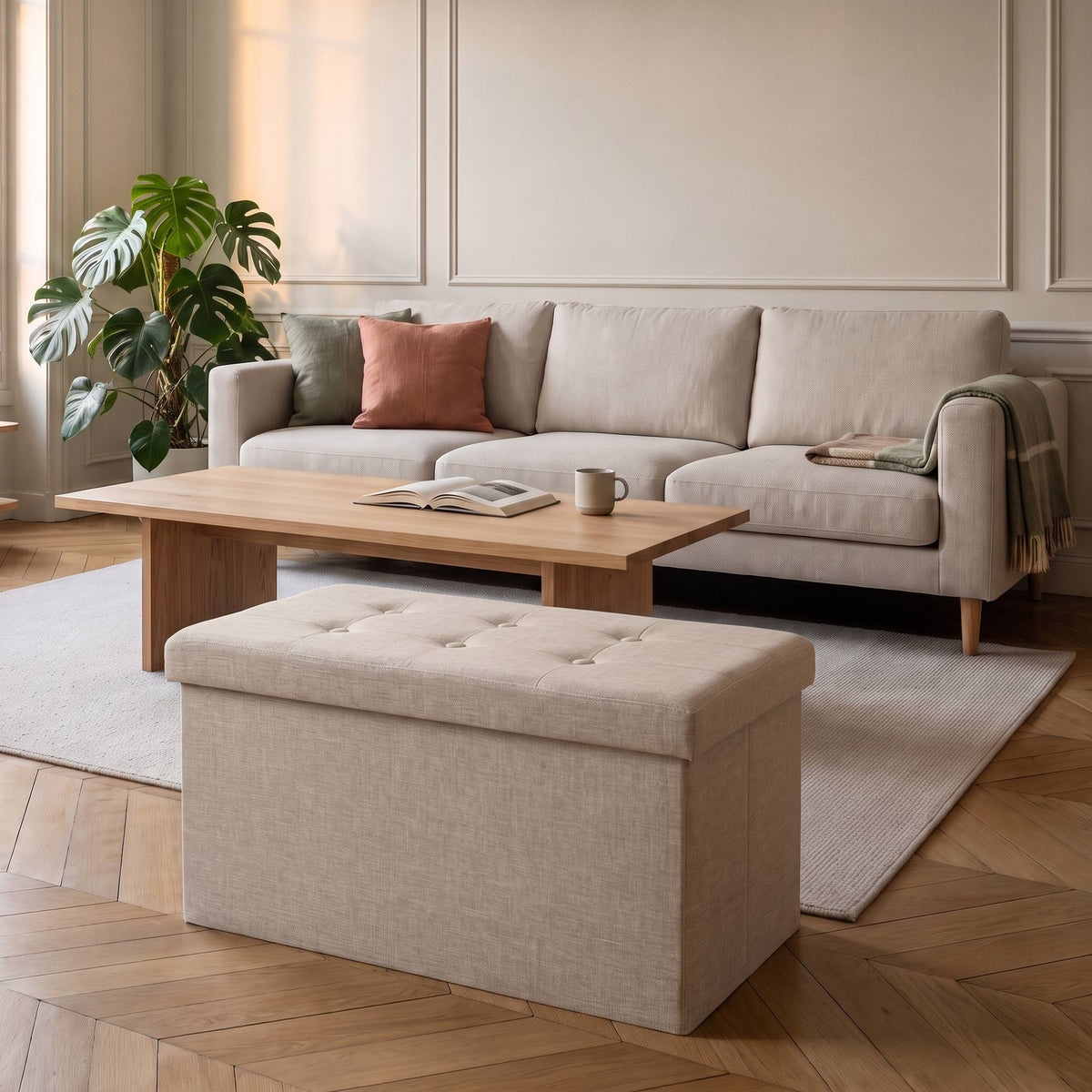 Tabouret coffre de rangement pliable beige posé sur le parquet d'un salon clair