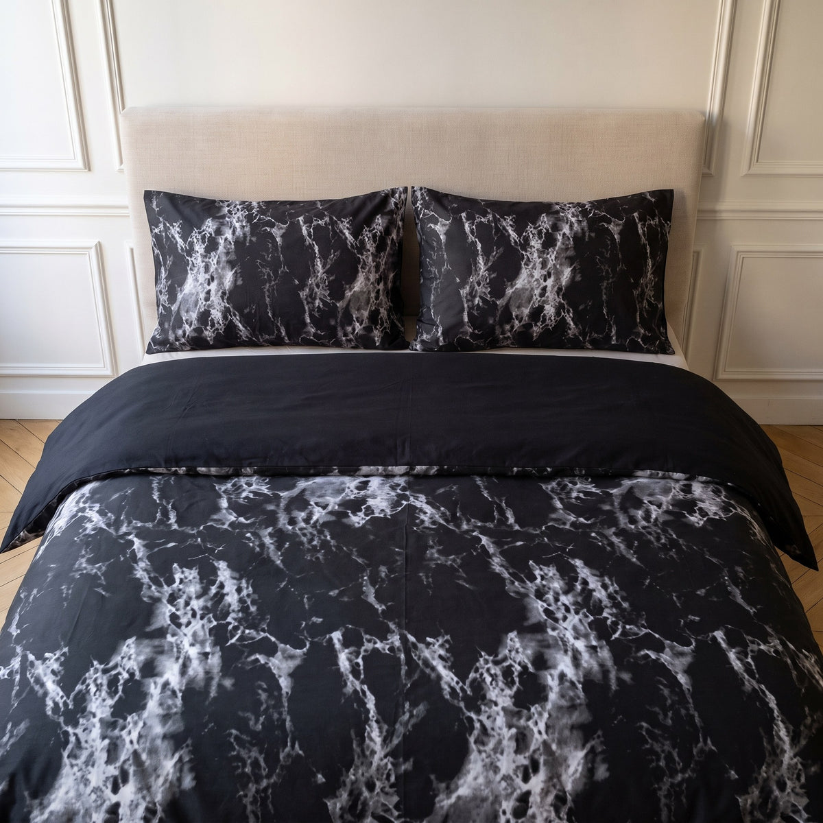 Tête de lit habillée de la housse de couette marbrée noire et de ses taies assorties