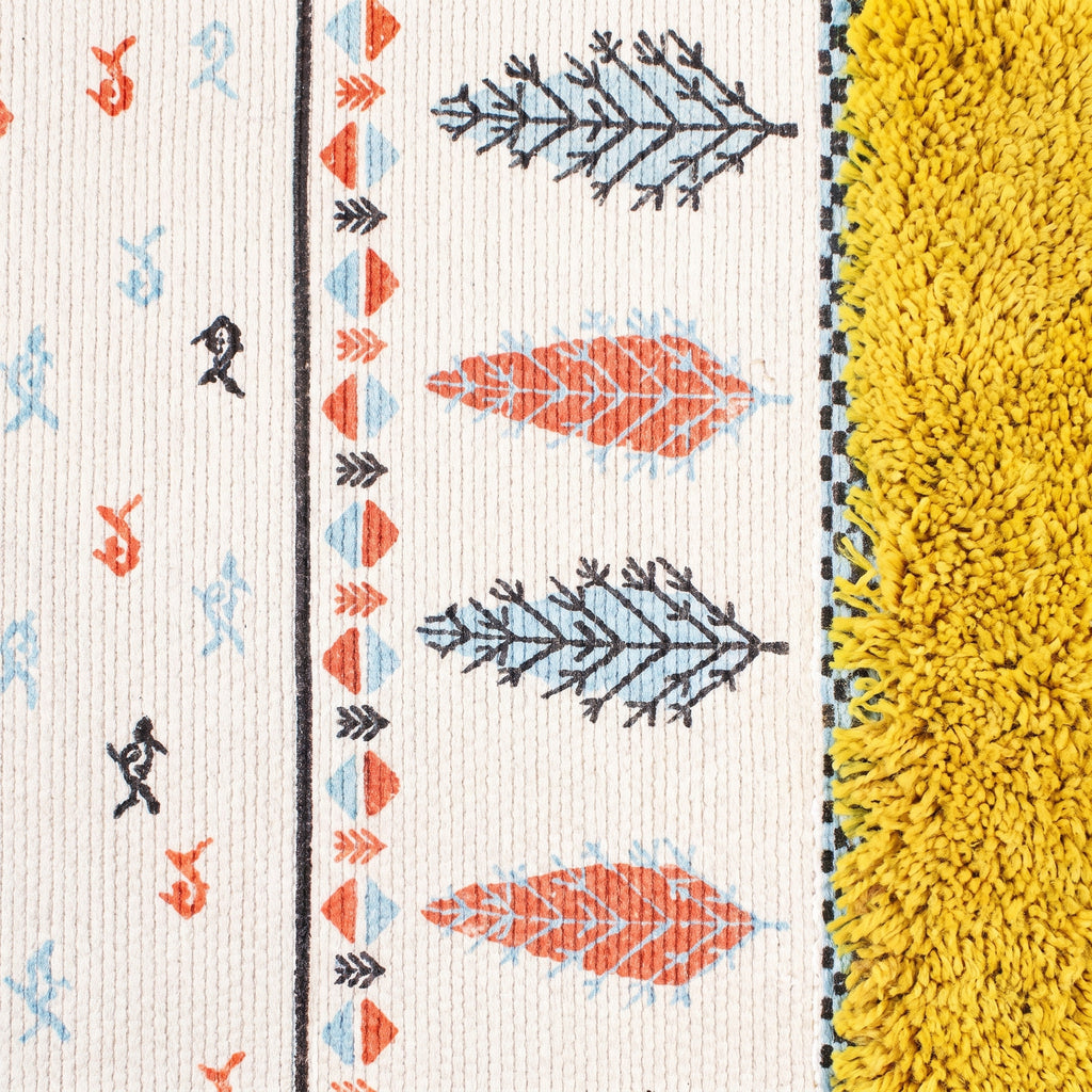 Motifs tissés du petit tapis : feuilles corail et bleu ciel, silhouettes et chevrons