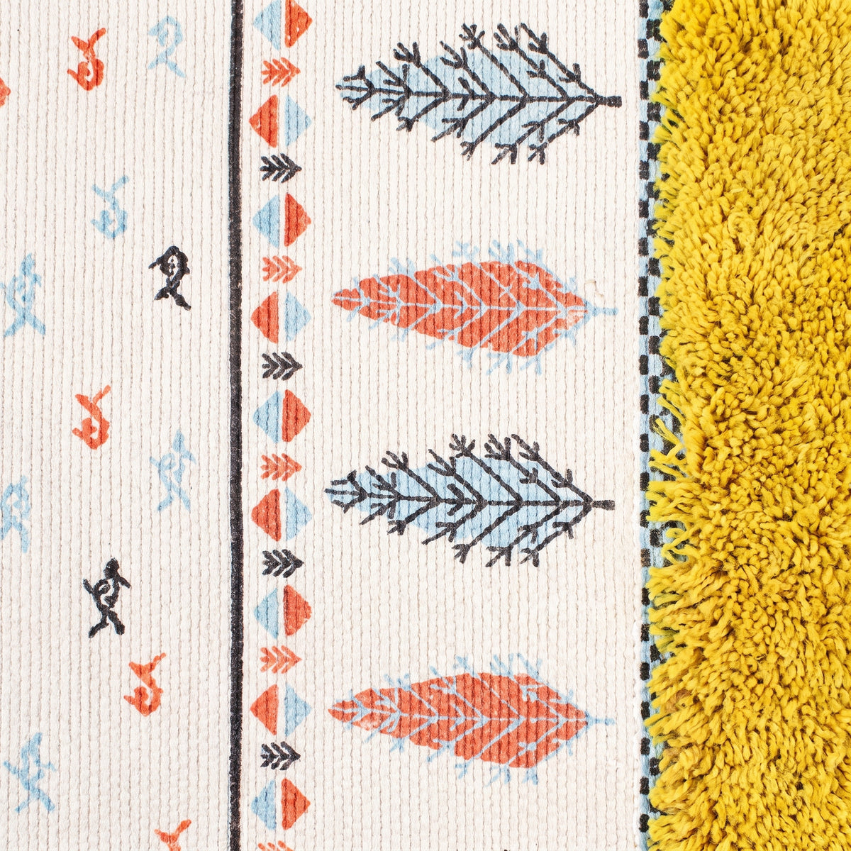 Motifs tissés du petit tapis : feuilles corail et bleu ciel, silhouettes et chevrons