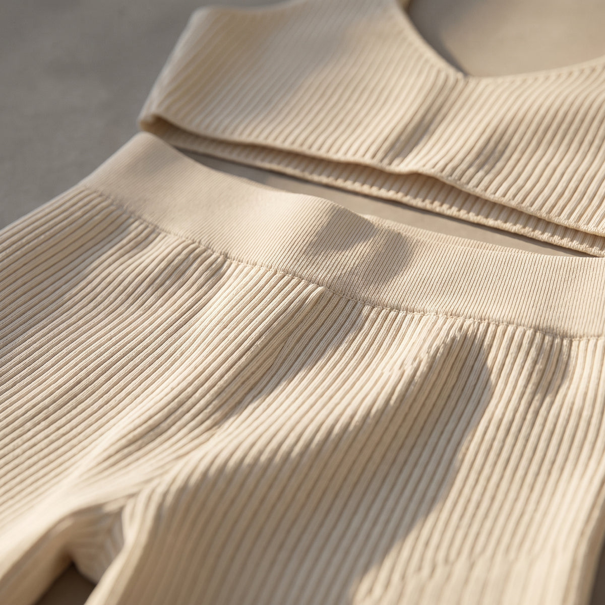 Gros plan de la maille côtelée beige et de la ceinture du short