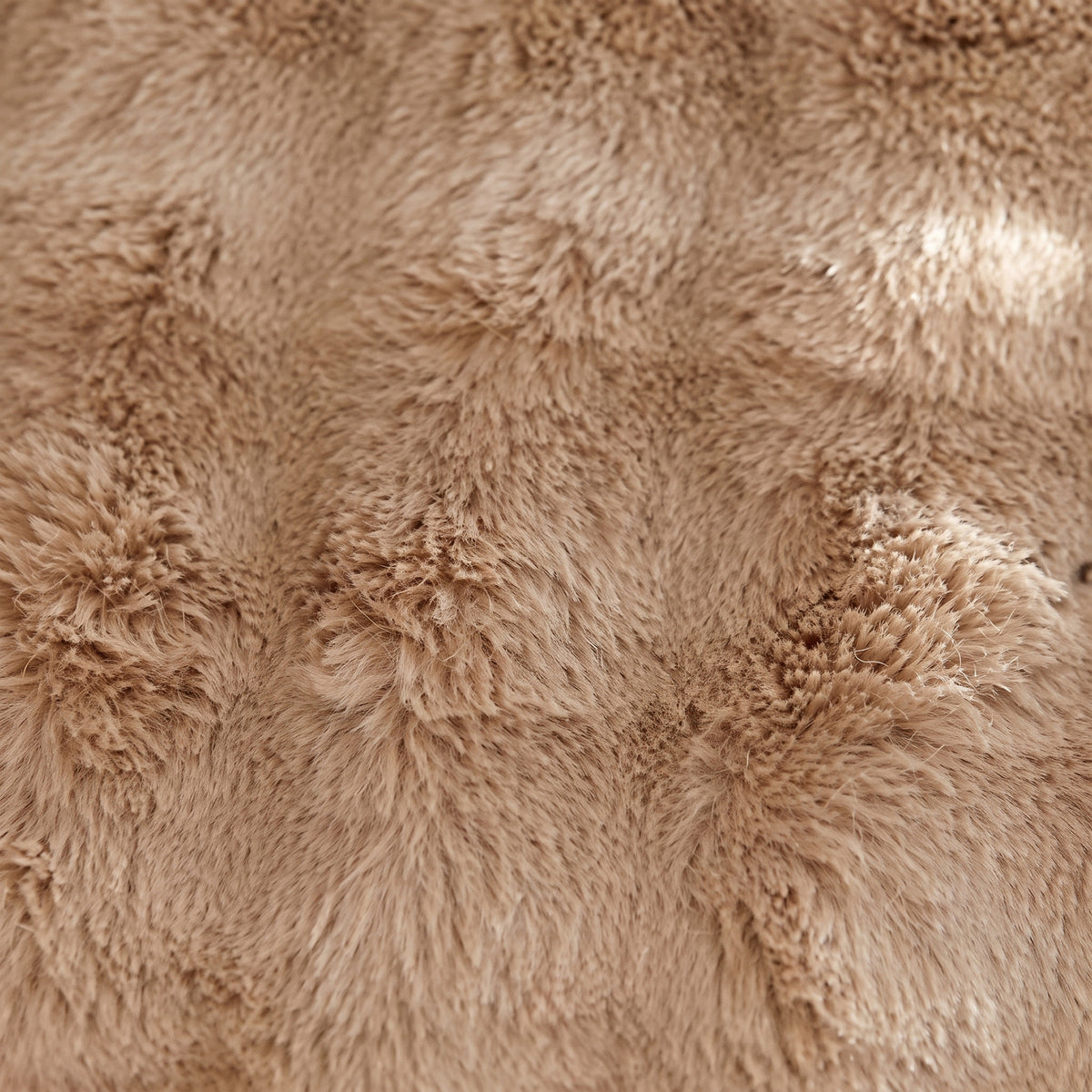 Gros plan sur le poil long et souple de la fausse fourrure beige