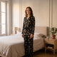 Pyjama femme en satin noir imprimé tigres porté debout dans une chambre