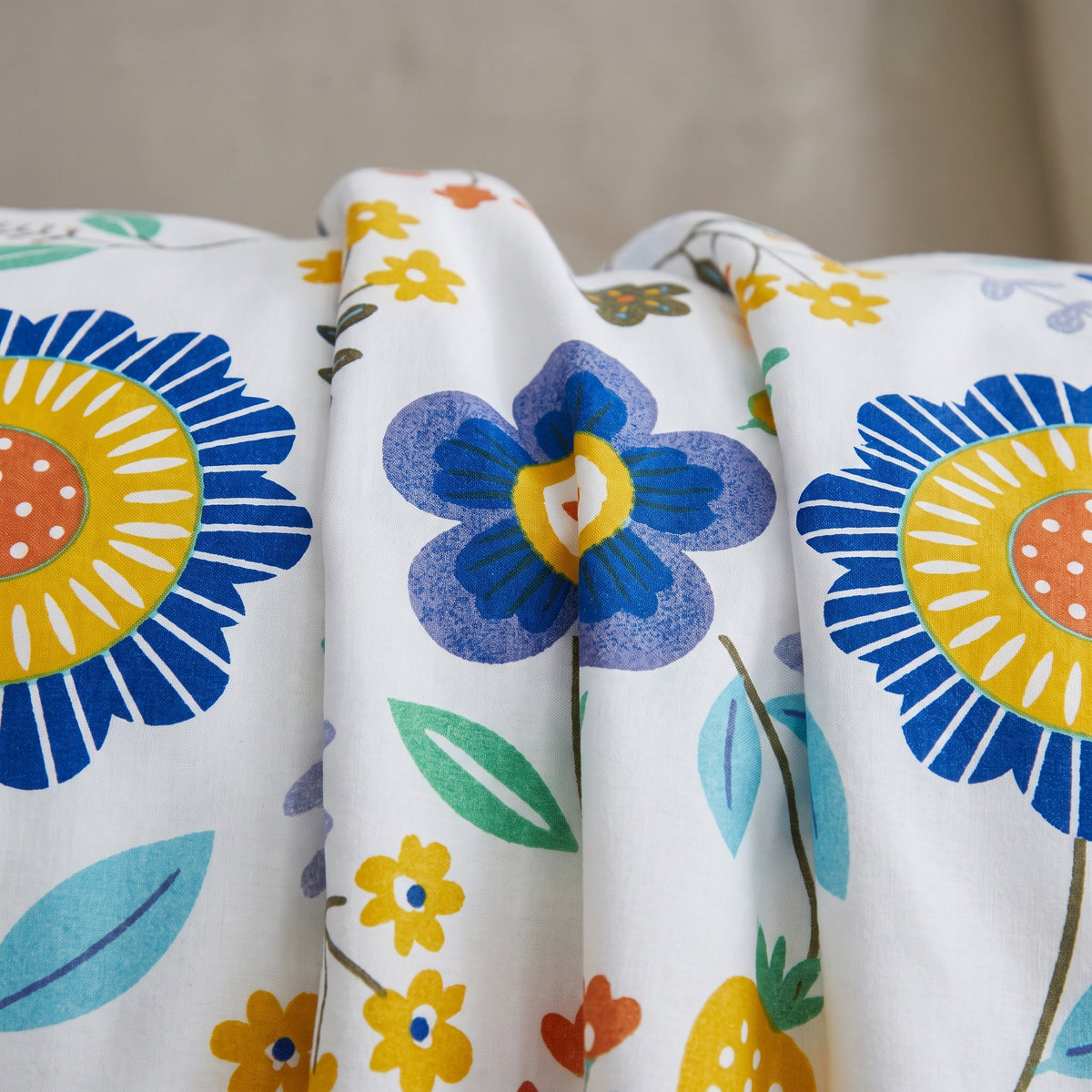 Gros plan du motif fleuri de la housse de couette, fleurs bleues et jaunes