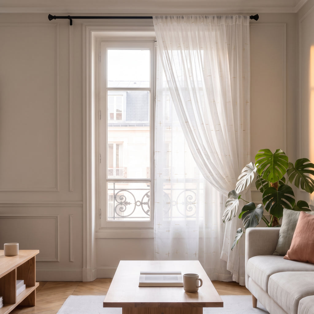 Voilage blanc à détails dorés ouvert sur le côté de la fenêtre du salon