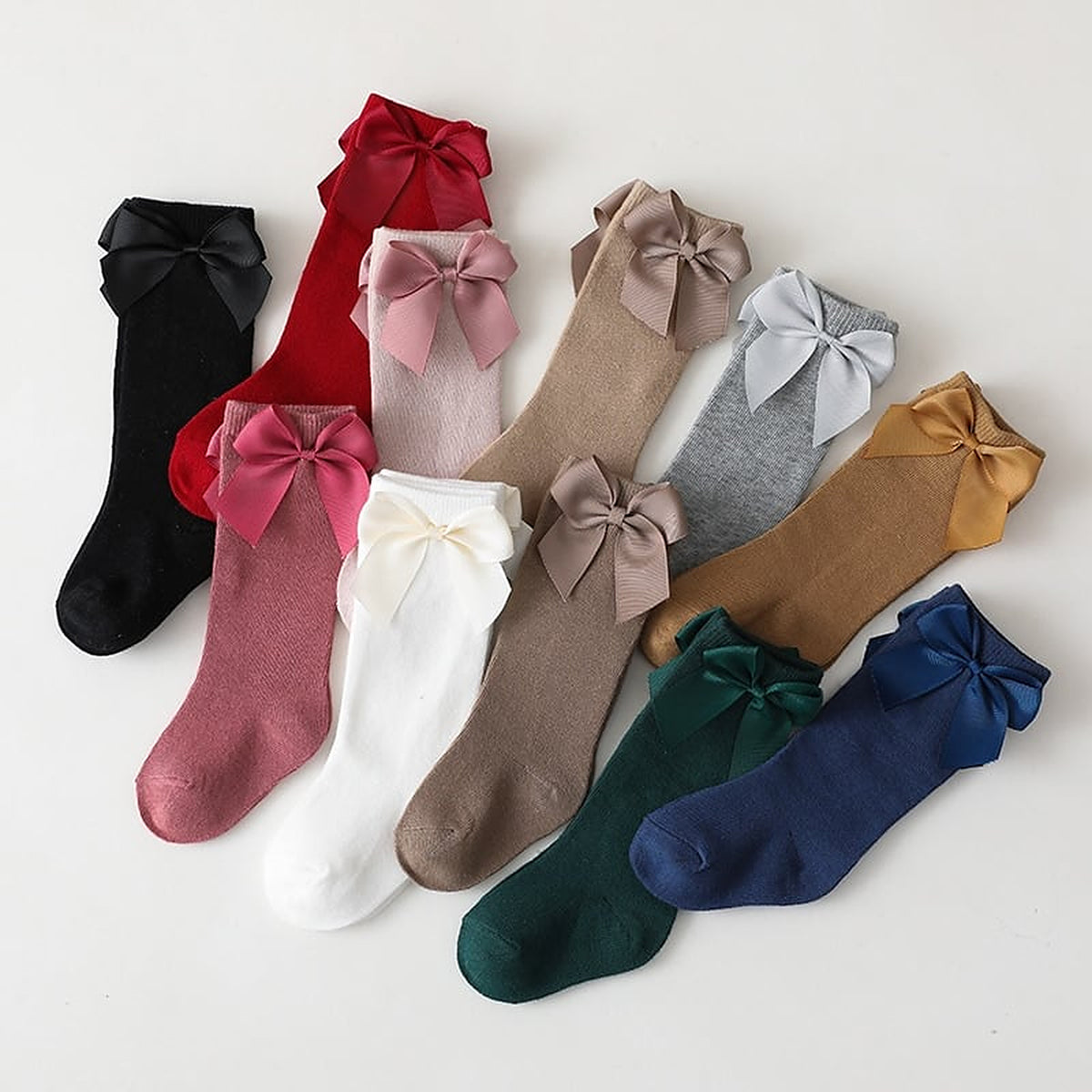 Les coloris de chaussettes hautes a noeud pour enfant, disposes cote a cote