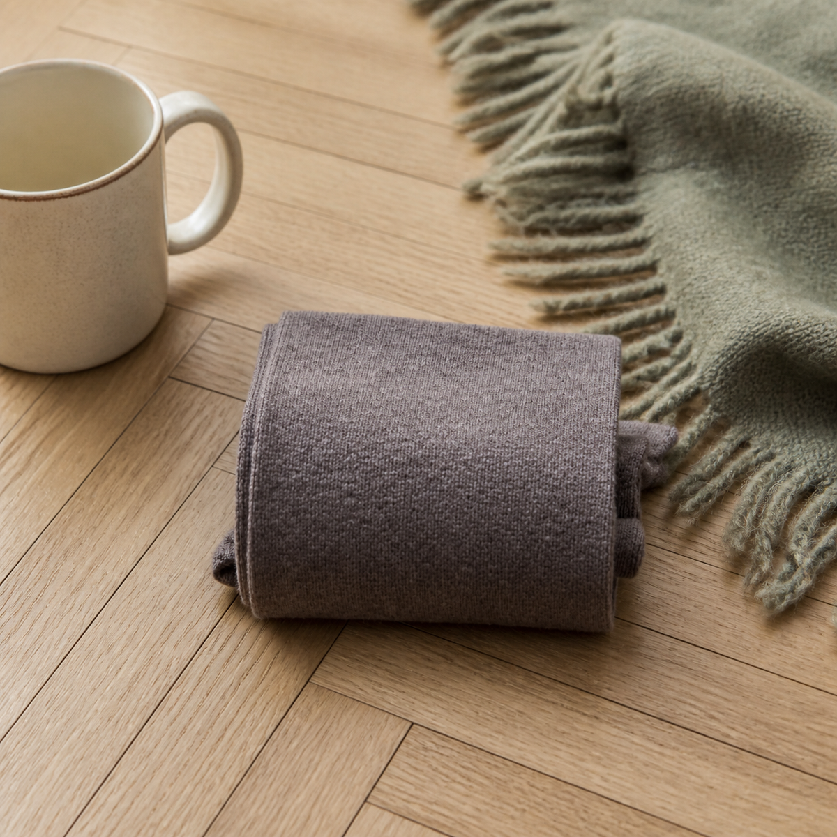 Chaussettes hautes femme coloris marron foncé pliées sur un parquet clair