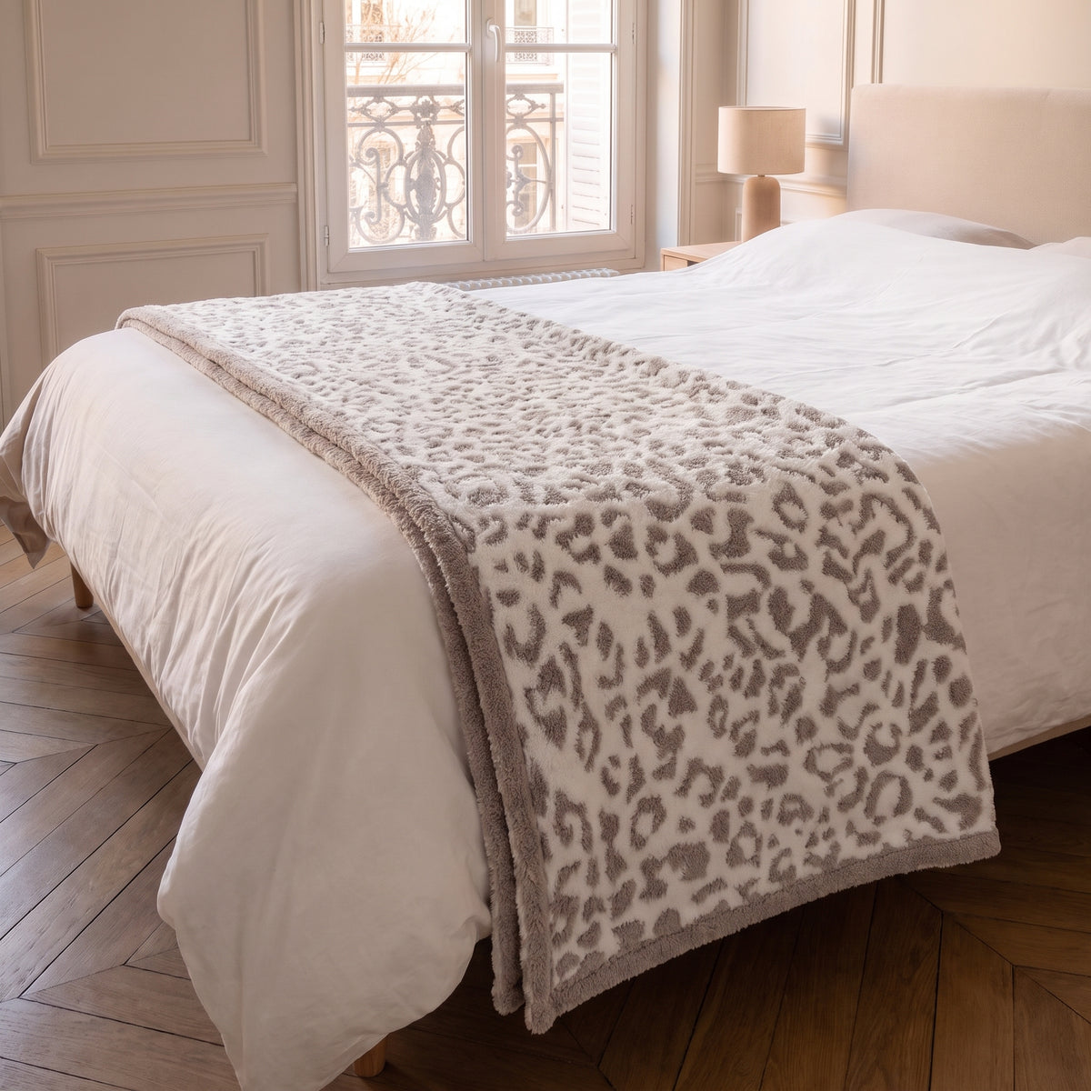 Plaid léopard beige plié en bandeau et posé en travers du pied d un lit Image