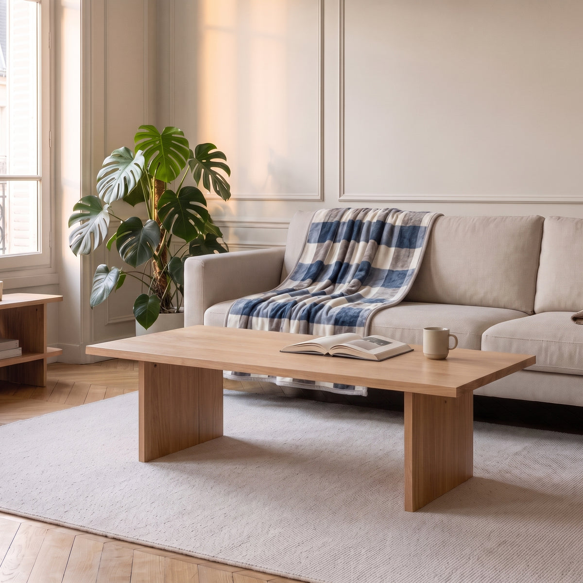 Plaid polaire à grands carreaux bleus posé sur une assise de canapé écru