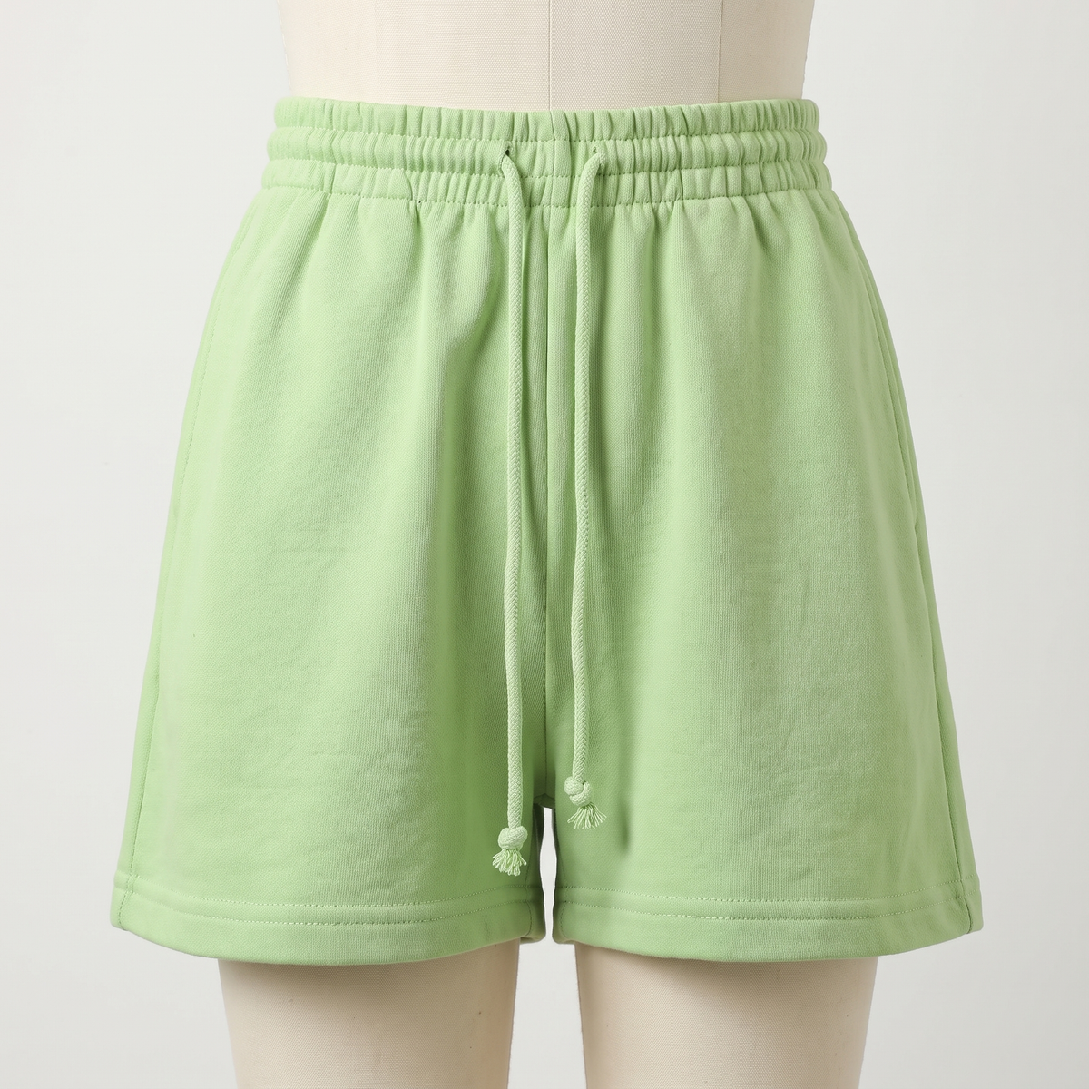 Packshot du short d’intérieur vert sur mannequin de couture, cordon long visible.