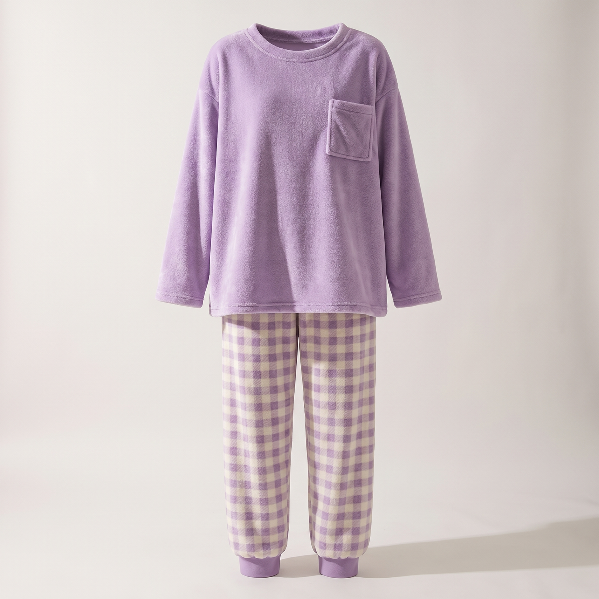Pyjama en flanelle violet présenté sur mannequin invisible, haut uni et pantalon à carreaux.