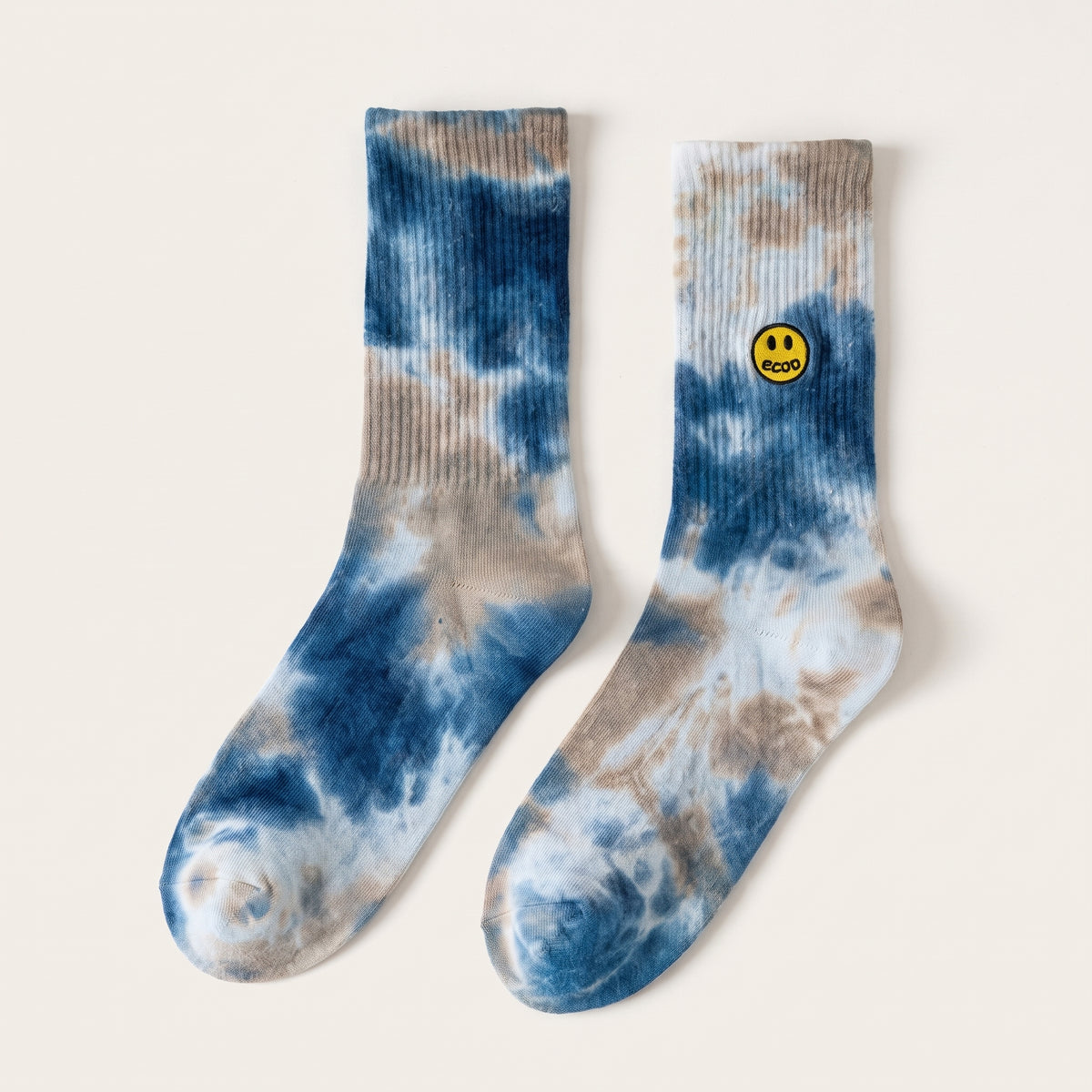 Paire de chaussettes smiley tie and dye bleu, posees a plat sur fond uni, ecusson fidele