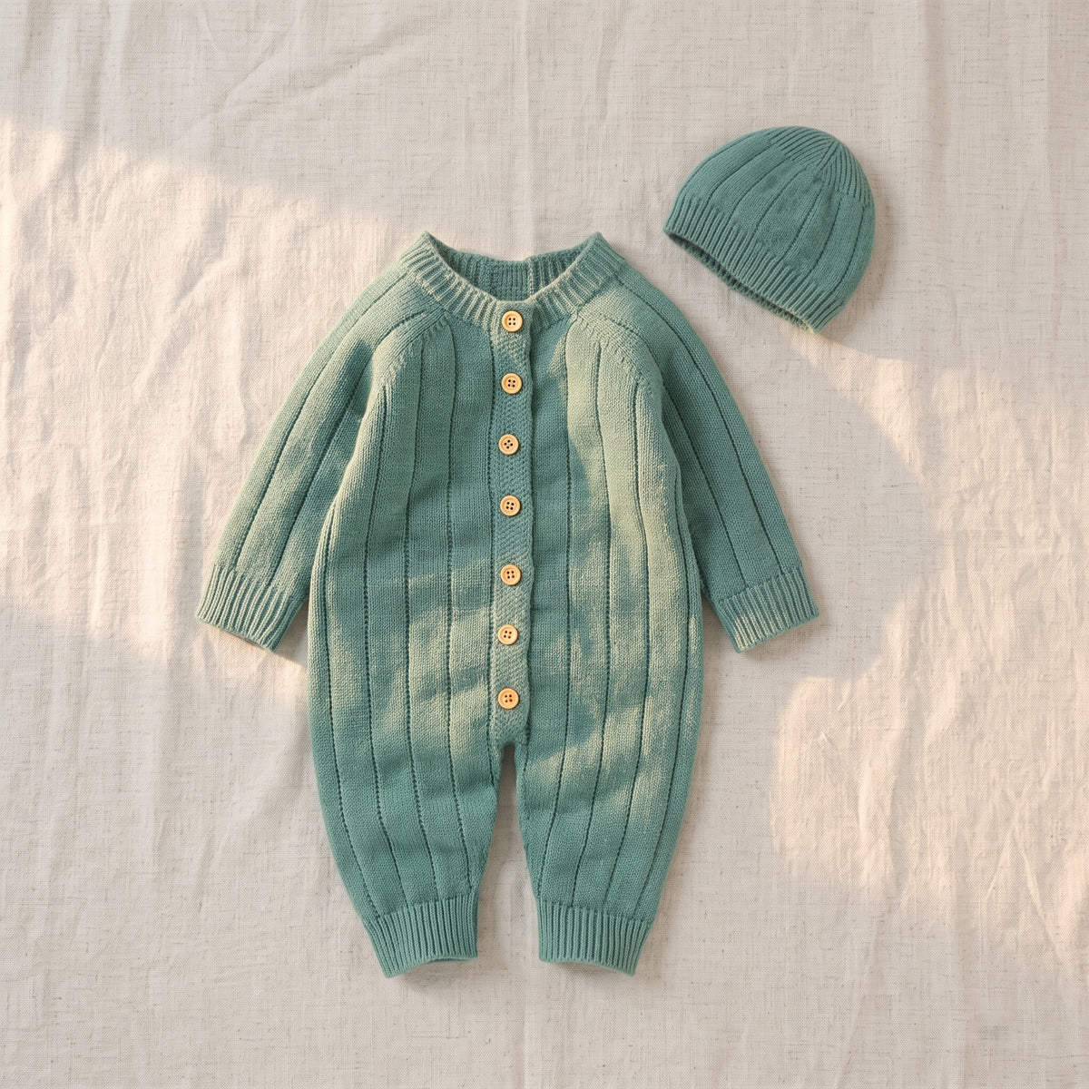 Barboteuse en tricot côtelé pour bébé présentée en forme portée sans corps, coloris vert sauge