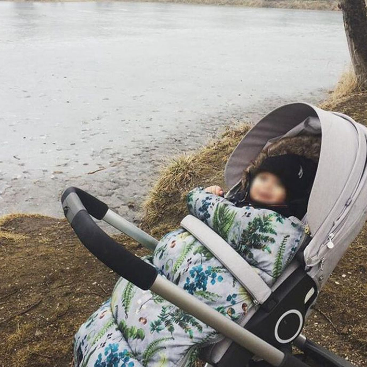 Nid d’ange fleuri installé dans une poussette avec bébé Image