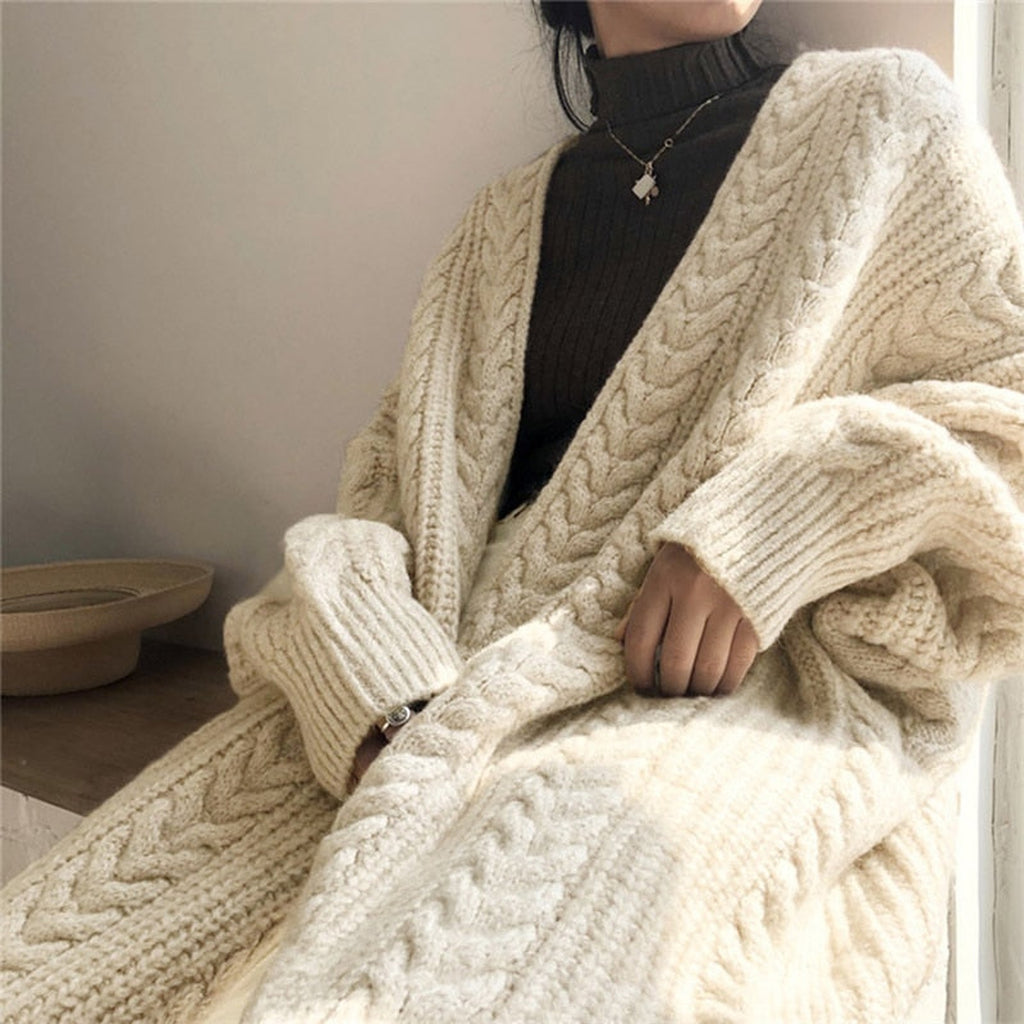Détail des grosses mailles torsadées du gilet long beige