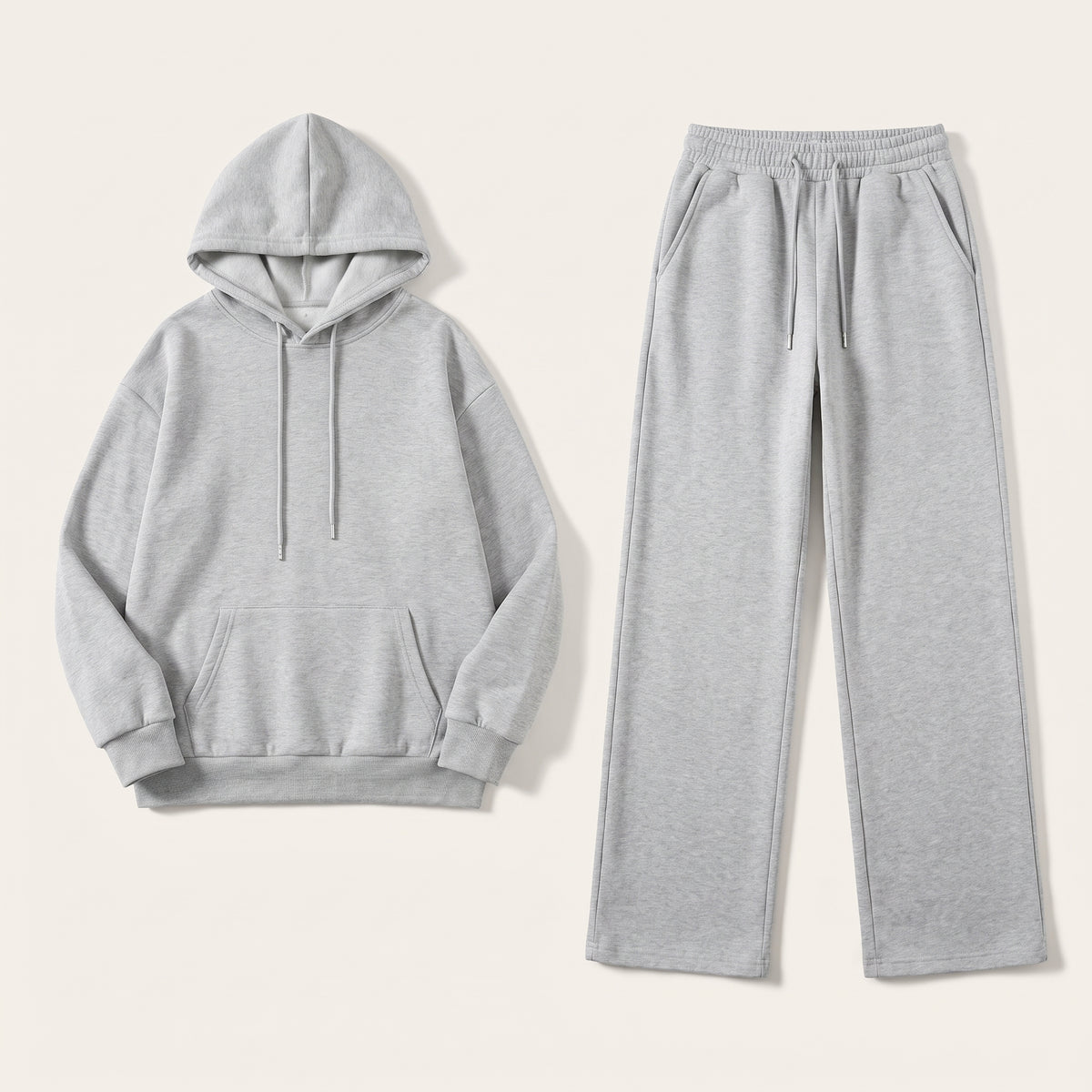 Ensemble jogging femme gris clair en packshot à plat, sweat à capuche et pantalon large