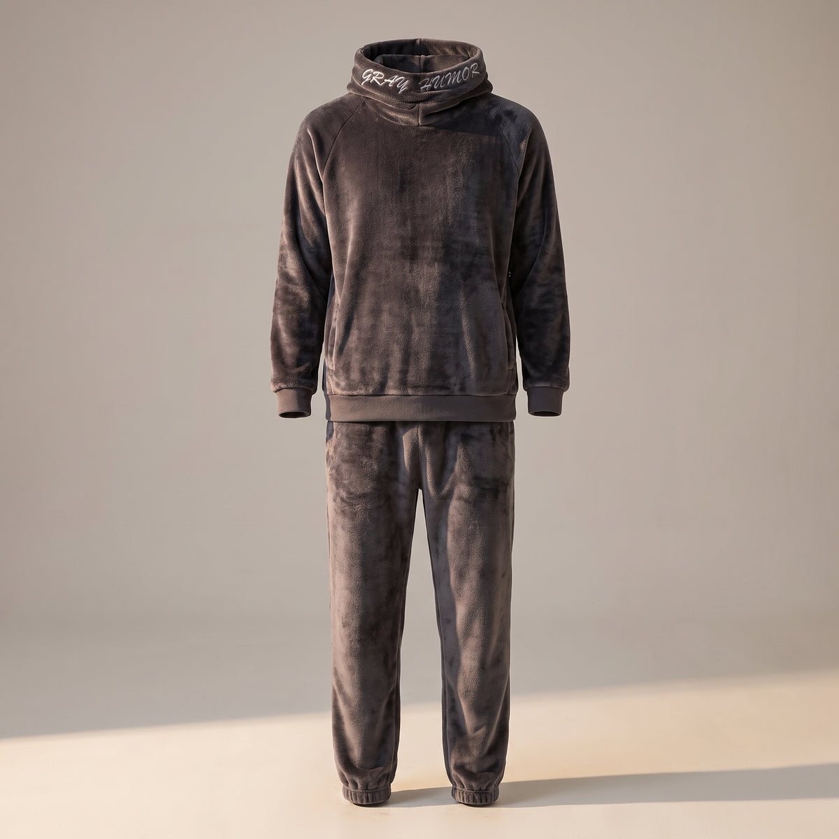 Pyjama polaire gris à capuche pour homme sur mannequin invisible, la coupe du vêtement sans le corps, de la capuche aux chevilles