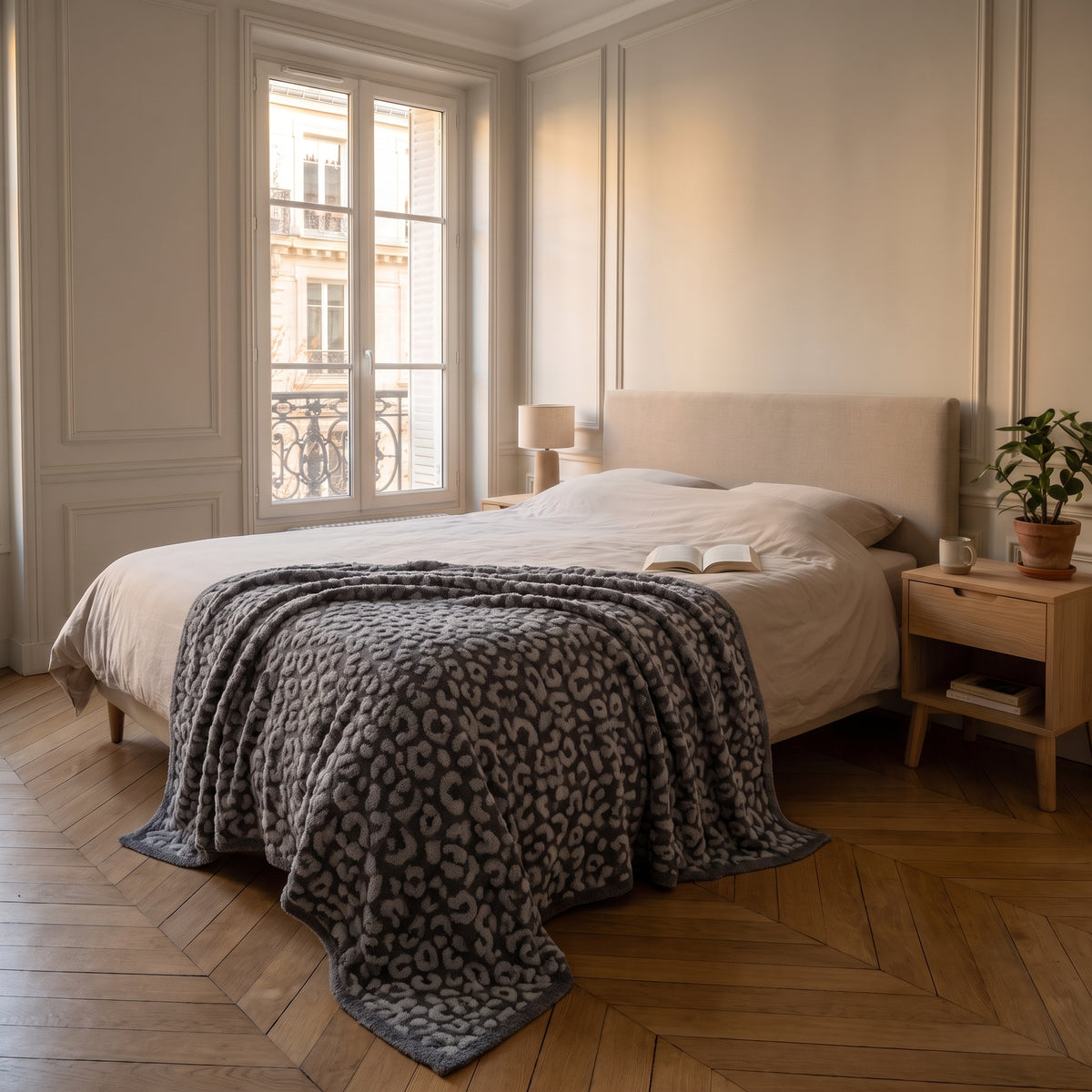 Plaid léopard gris déplié sur un lit deux places