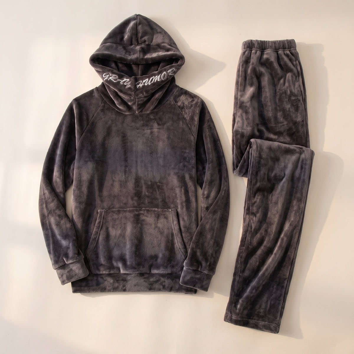 Pyjama polaire gris à capuche pour homme, le haut et le pantalon seuls, posés à plat sur un fond clair