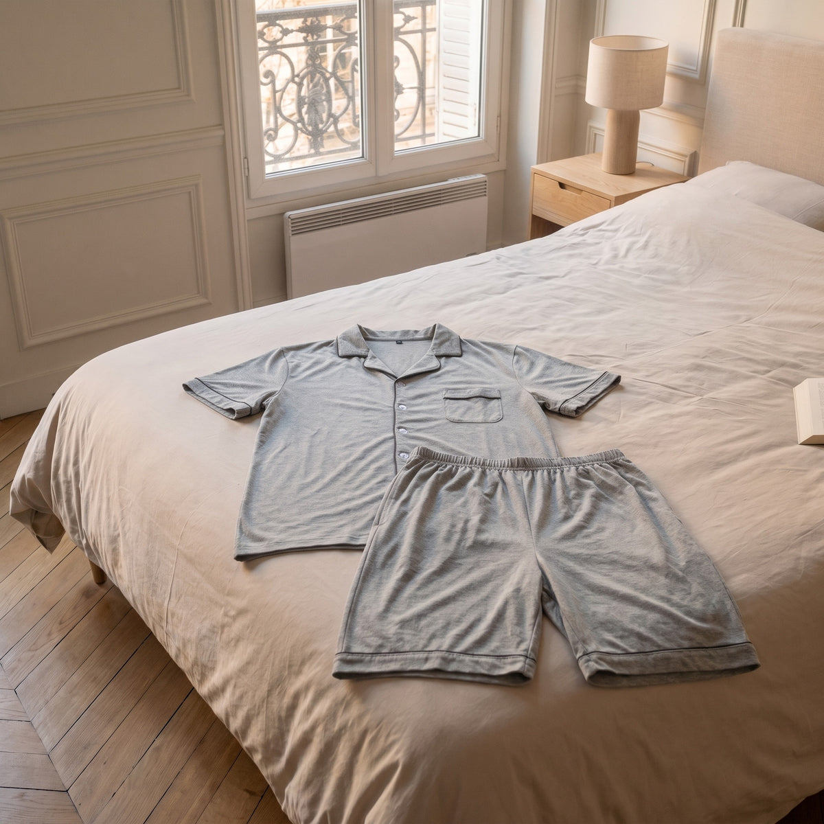 Pyjama d'été en coton gris chiné posé à plat sur le lit, chemise et short