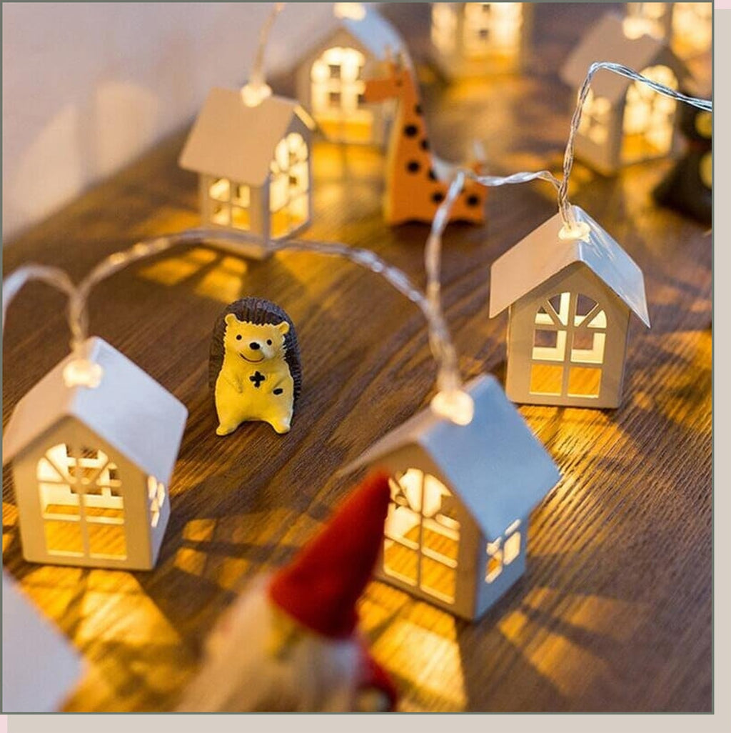Guirlande lumineuse de Noël à maisons installée sur une table en bois